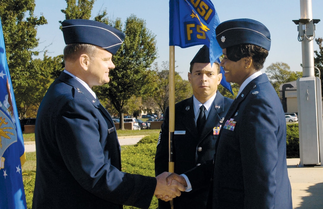 Brig. Gen. Dana A. Simmons, commander of the Air Force Office of Special Investigations, shakes hands with Lt. Col. Anita L. Lightfoot, after she accepted, commander of the AFOSI Field Support Squadron on Oct. 30 here.