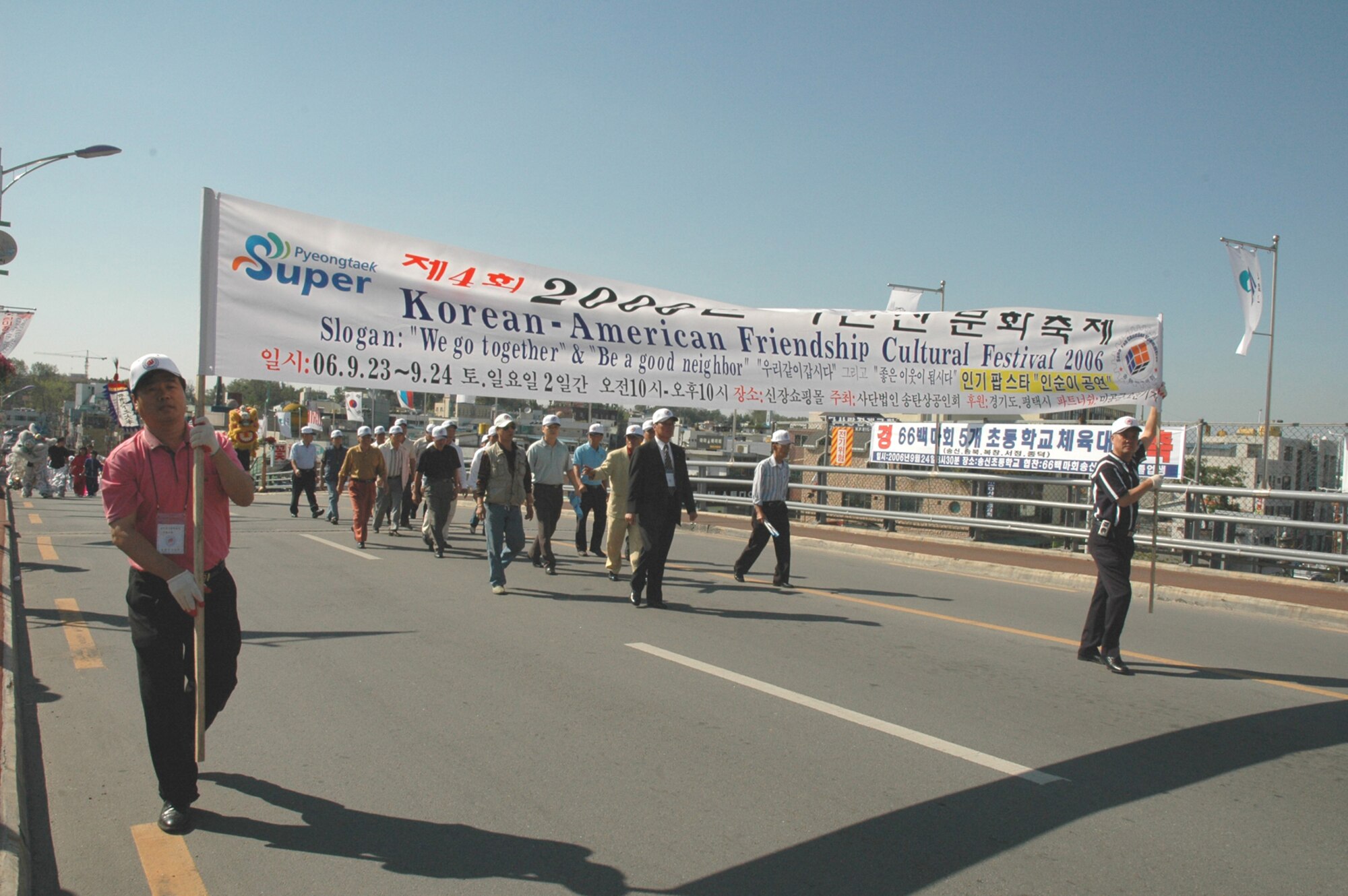 SONGTAN, Republic of Korea --  Members of the Songtan Chamber of Commerce hold up the 2006 Korean/American Friendship Festival banner during the parade Sept. 23, 2006. The 2007 Korean/American Friendship Festival takes place Oct. 13 and 14 in the Shinjang Shopping Mall just outside the main gate here. (U.S. Air Force photo by Tech. Sgt. Michael O'Connor)