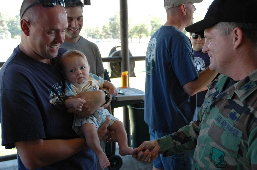 HILL AIR FORCE BASE, Utah-- Col. Scott Chambers, 75th Air Base Wing commander, makes a pit stop at the 75th Medical Group's picnic at Centennial Park.  He greets Tech. Sgt. Steven Henry, NCOIC for the 75th MDG education and training office, and his son Cohen.