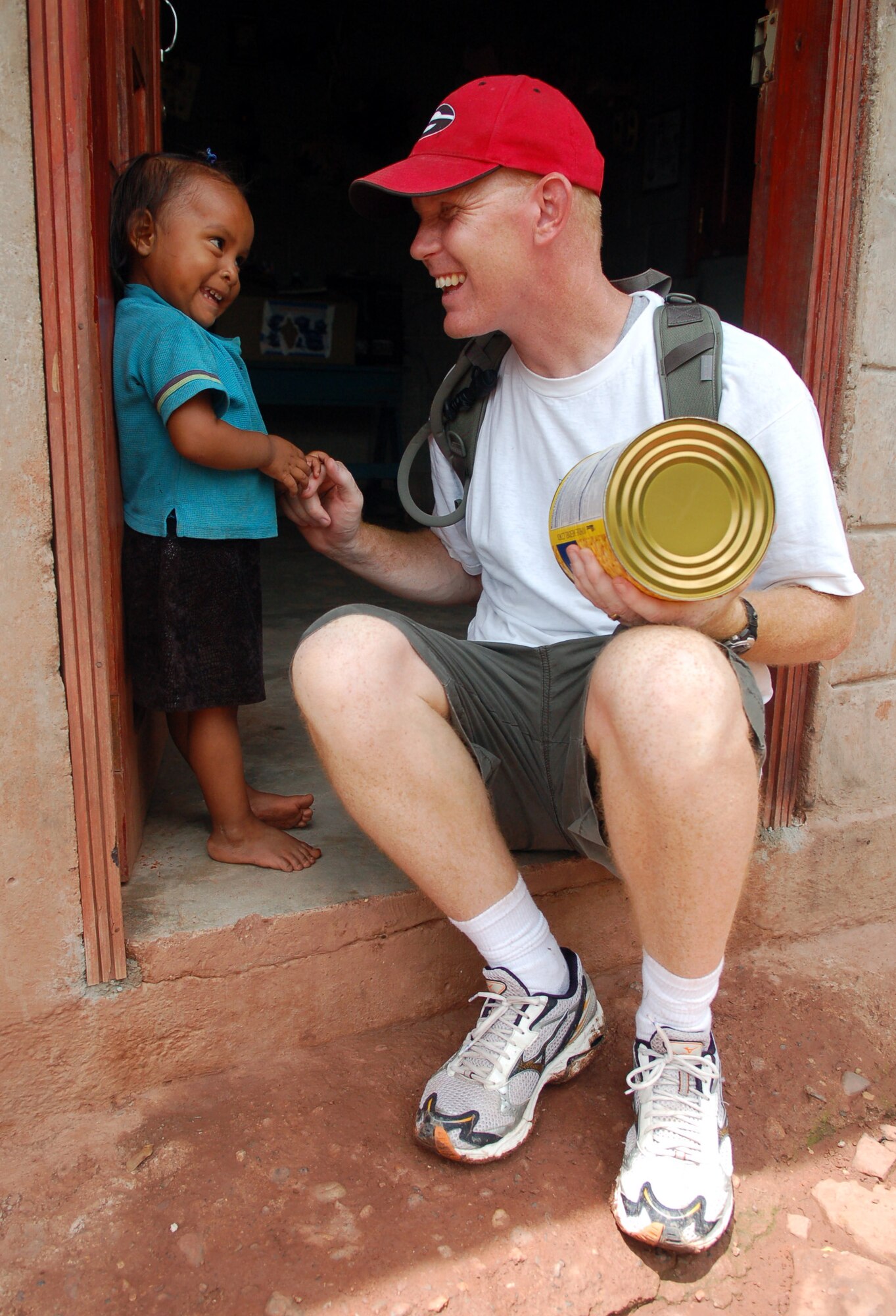 MATA DE PLATANO, Honduras -- Air Force Chaplain (Capt.) Chad Bellamy, Joint Task Force-Bravo chaplain, plays with a young Honduran girl during a break on a nearly five-mile hike to deliver the supplies to families living in the mountains.     (U.S. Air Force photo by Staff Sgt. Austin M. May)