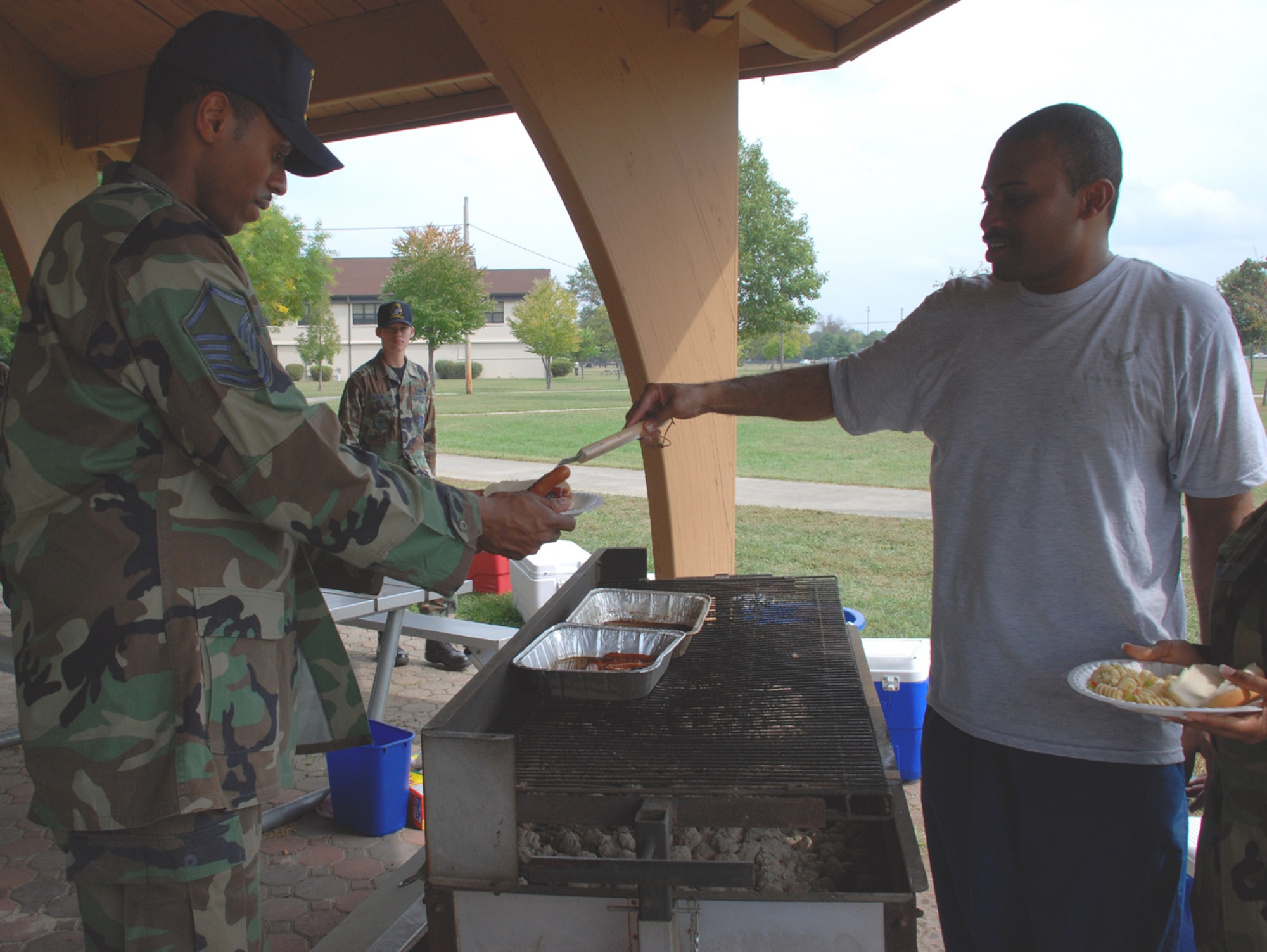 Staff Sgt. Danish Santiago, 305th Mission Support Squadron unit training manager, serves Master Sgt. Christopher Robinson, 305 MSS NCO in charge First Term Airmen Center, food during the 305th Services Squadron/305 MSS luncheon here Sept. 27. The two squadrons are scheduled to merge into the Force Support Squadron in January 2008. (U.S. Air Force photo/Airman 1st Class Rebekah Phy)