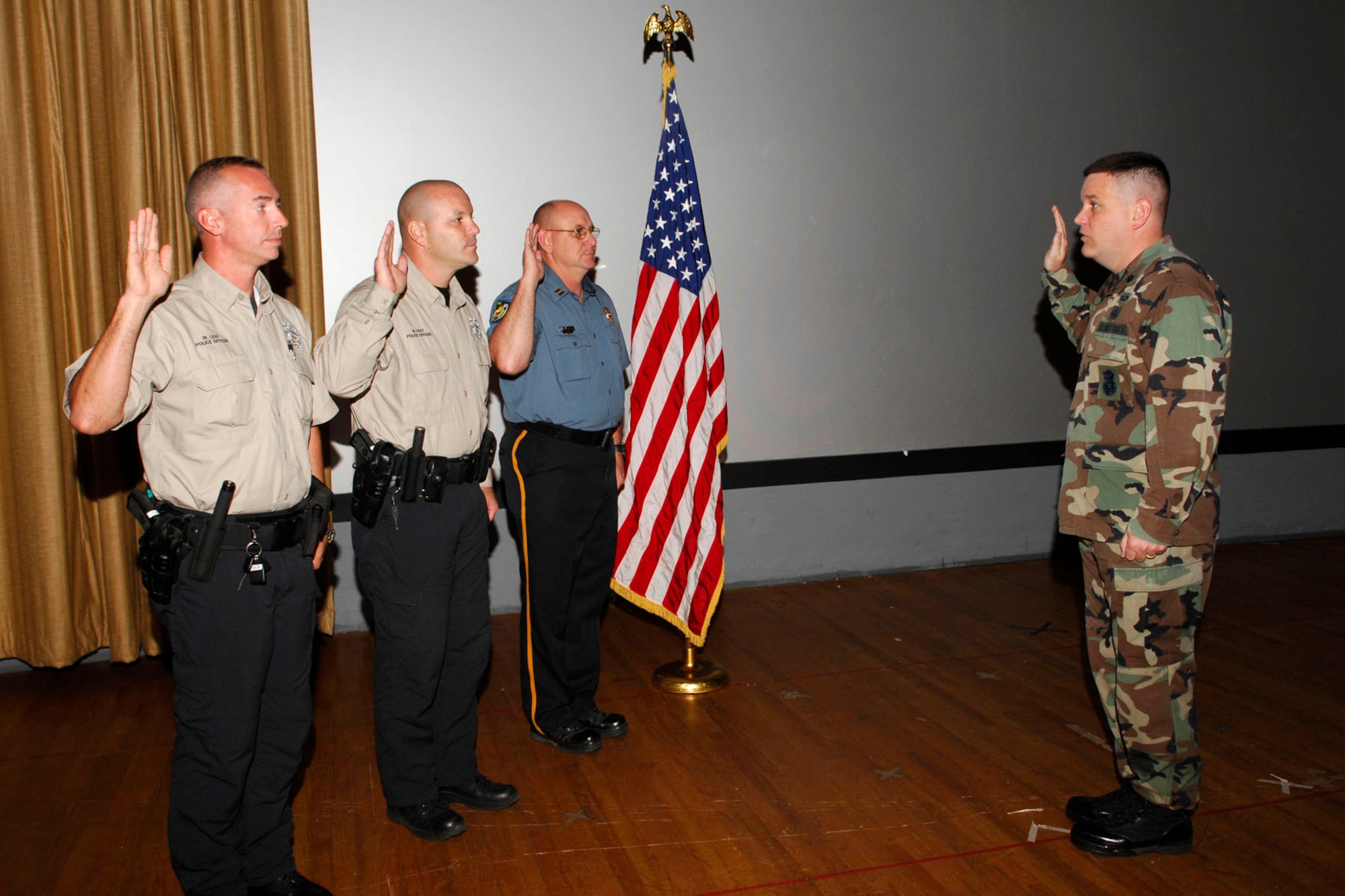 Lt. Col. Timothy Meserve, 96th Security Forces commander, administers the oath to Officers Jamie Leaf and Brad Yost, and Capt. Joel Byrd.  Officers Leaf and Yost recently graduated from Federal Law Enforcement Training Center.