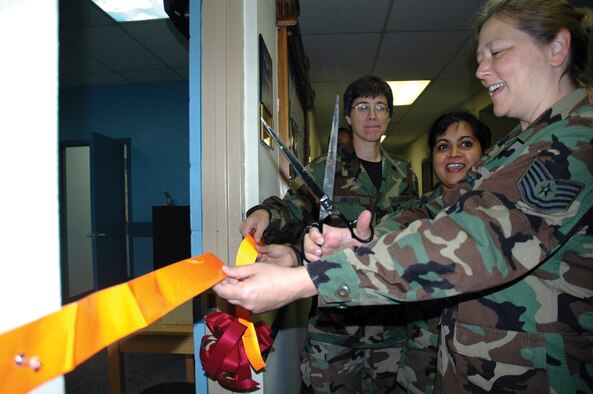 Tech. Sgt. Diana McCarty, 919th Mission Support Flight customer assistance chief, cuts ribbon during the grand opening of the wing's Customer Service office. The office moved from the second to the first floor of the Headquarters Building 3077, Room 7, taking over the wing's Public Affairs office area, which has moved down the hall to Room 2. The office serves all military personnel, dependants, and Department of Defense civilian employees. (U.S. Air Force Photo\Jasmine DeNamur)