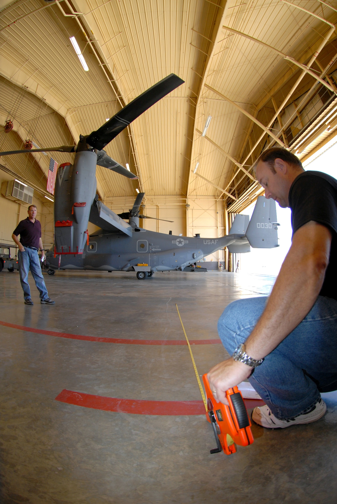 David Lee, left, and Todd Richardson take measurements in a hangar during tests to determine the suitability of the base's hangars to support the CV-22 Osprey Sept. 25 at Cannon Air Force Base, N.M. The men, who provide contract support for the CV-22 program, work for the Boeing Corp. at Fort Walton Beach, Fla. Cannon AFB will be transferred from Air Combat Command to Air Force Special Operations Command Oct. 1. CV-22s are among the special operations aircraft to be assigned to the 27th Special Operations Wing at Cannon AFB. The wing, formerly designated the 27th Fighter Wing, operated F-16 Fighting Falcons at the base from 1995 to 2007. (U.S. Air Force/Chief Master Sgt. Gary Emery)
