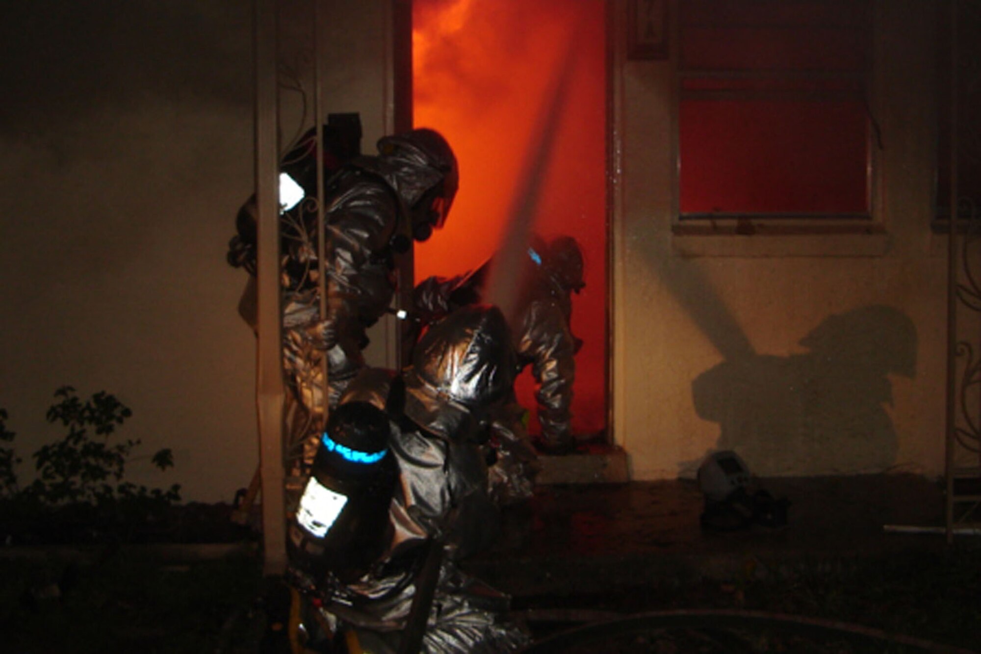 Firefighters enter a burning house during a training exercise.  October is Fire Prevention Month.
