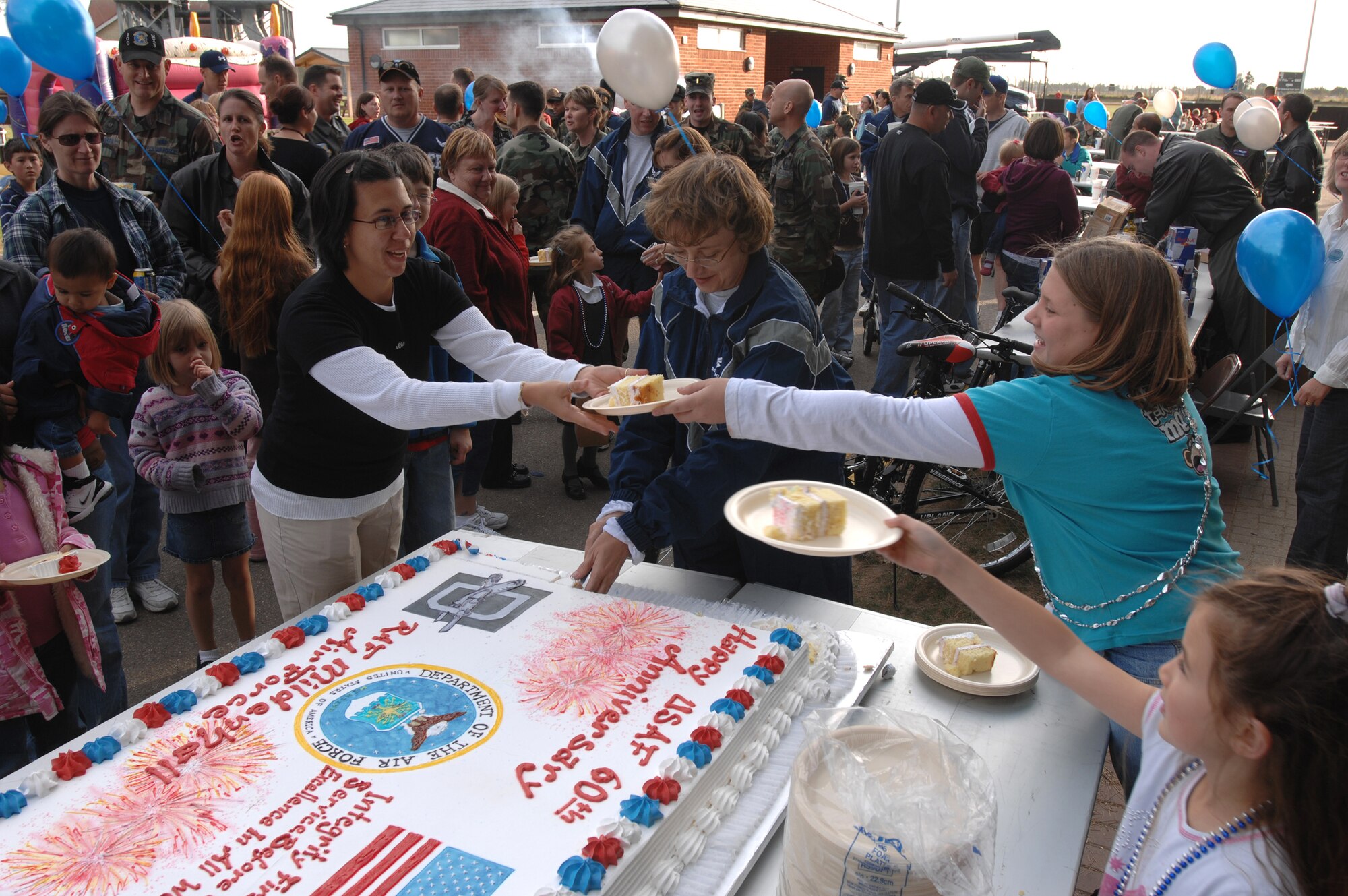 Col. Eden Murrie,100th Air Refueling Wing commander, serves pieces of a giant cake at Heritage Park, Sept. 18. Colonel Murrie was serving cake as part of RAF Mildenhall's Air Force birthday bash to celebrate the 60th anniversary of the Air Force.(U.S. Air Force photo by Tech. Sgt. Tracy L. DeMarco)
