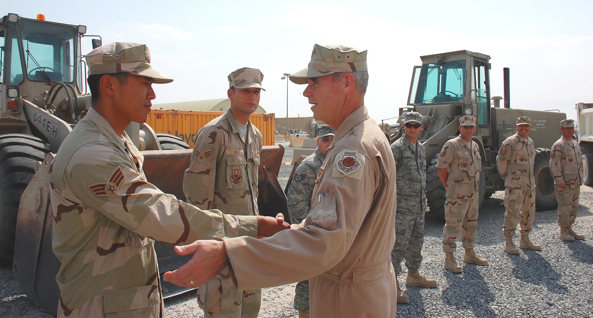 SOUTHWEST ASIA -- Senior Airman Khanh Le, 386th Expeditionary Civil Engineering Squadron pavement equipment operator, greets Maj. Gen. William "Dutch" Holland, Vice Commander, 9th Air Force and Deputy Commander, U.S. Central Command Air Forces, during General Holland's visit to an undisclosed location in Southwest Asia Sept 30.  Airman Le is deployed from Hickam AFB, Hawaii.  (U.S. Air Force photo by Staff Sgt. Tia Schroeder)