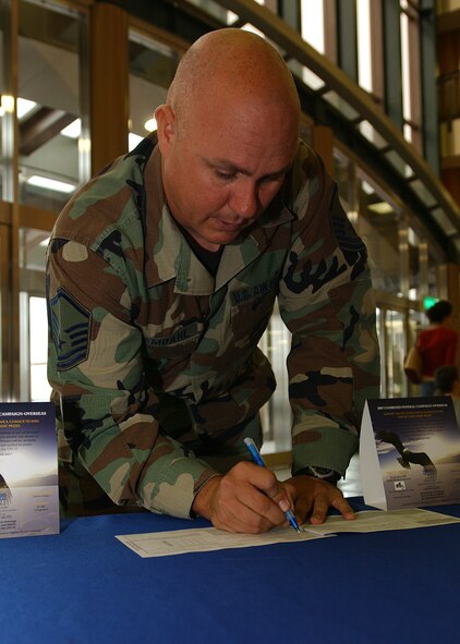YOKOTA AIR BASE, Japan - Master Sergeant Scott Samdahl, from the 730th Air Mobilty Squadron, fills out the first Combined Federal Campaign (CFC) pledge on October 1, 2007.  The CFC gives military members and civilians a chance to donate to over 2,000 charitable organizations and give money back to the base to help pay for quality of life initiatives. (U.S. Air Force photo by Airman First Class Jonathan Fowler)