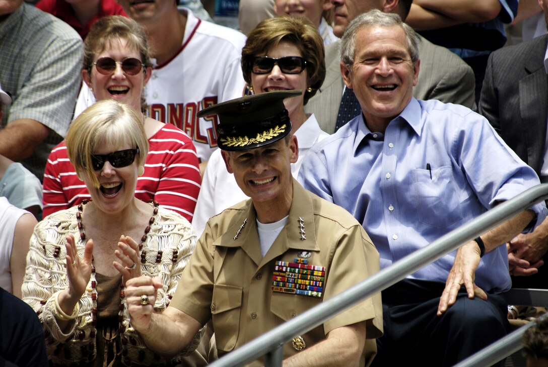 President George W. Bush and the first lady, Laura Bush, joined by Chairman of the Joint Chiefs of Staff Marine Gen. Peter Pace and his wife, Lynne, cheer during the first tee ball game of the 2006 season on the White House South Lawn in Washington, D.C., June 23, 2006.