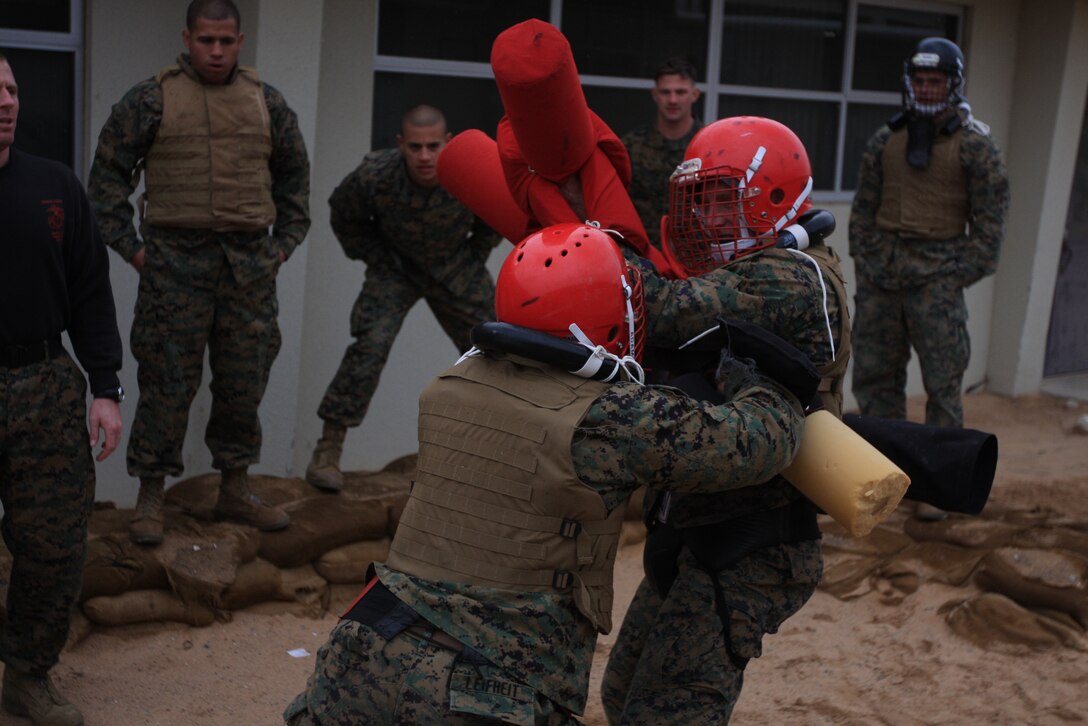 Cpl. Cody Leifheit (left) shoves Sgt. Alex Kessell, trying to throw him off balance during a pugil stick sparring match Jan. 20 behind the Marine Wing Support Squadron 374 headquarters building during the Marine Corps Martial Arts Instructor Course.