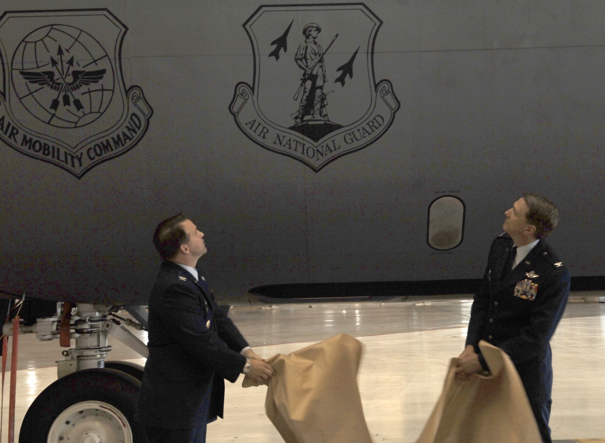 FAIRCHILD AIR FORCE BASE, Wash. – Col. Thomas Sharpy (left), 92nd Air Refueling Wing commander, and Col. Greg Bulkley, 141st Air Refueling Wing commander, unveil a KC-135 Stratotanker’s new joint-patch painting at a Classic Association ceremony here Oct. 1. The side-by-side patches of Air Mobility Command’s 92nd ARW and the Washington Air National Guard’s 141st ARW mark a formal merge of the two wings, the first of its kind in the Air Force. According to an agreement between the two wings, Guard servicemembers now have use of the active-duty KC-135s for training, missions and short-notice emergencies. (U.S. Air Force photo/Senior Airman Chad Watkins)