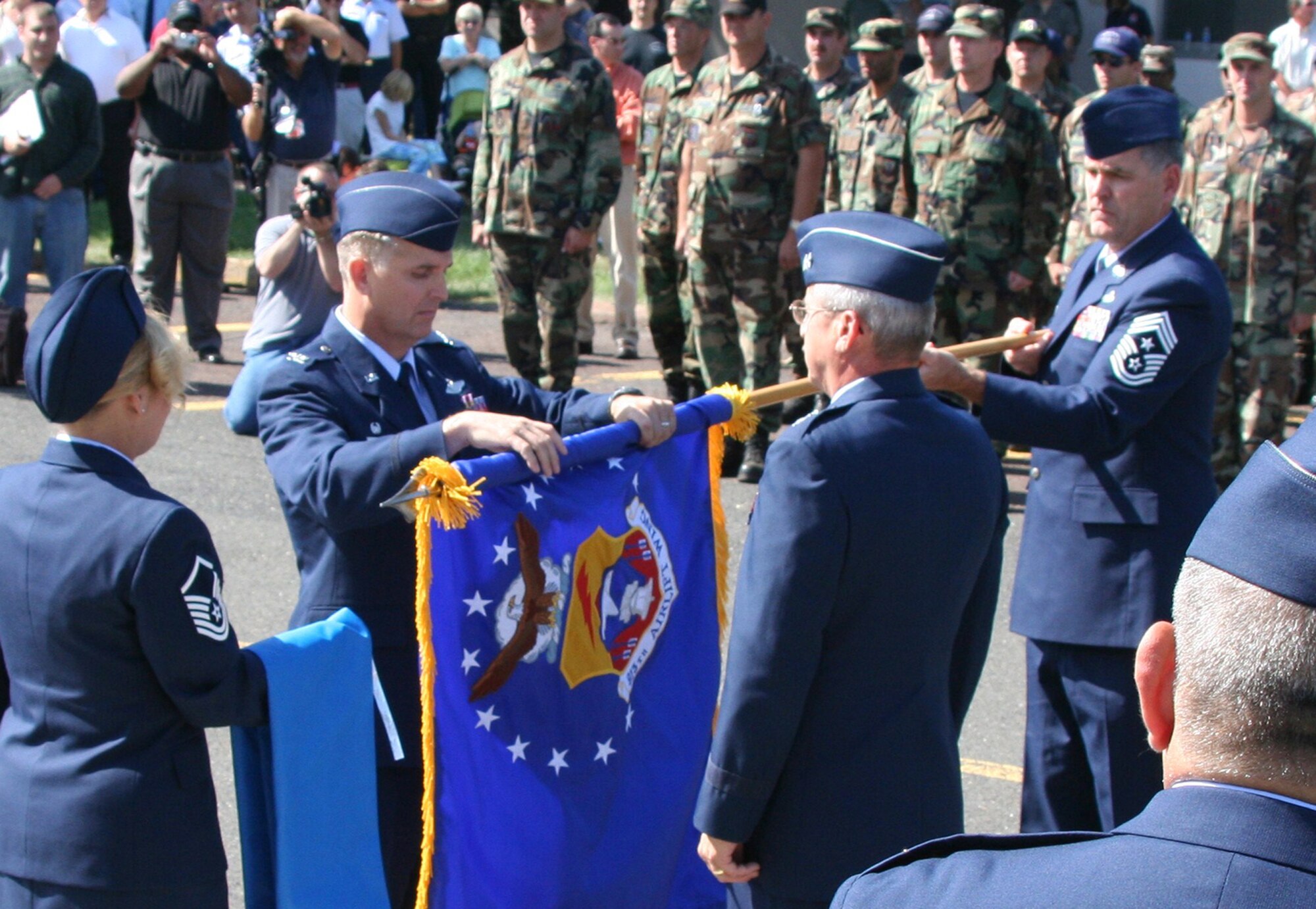 Col. Giordano "Jody" McMullen, 913th Airlift Wing commander, furls the wing flag prior to relinquishing it to 22nd Air Force Commander Maj. Gen. Martin M. Mazick, during the Sept. 30, 2007 inactivation ceremony. Holding the flag is 913th AW Command Chief Master Sgt. Clifford Van Yahres. The 913th AW was inactivated as part of an Air Force Reserve Command 2007 Programmatic Budget Directive action. The ceremony was a somber moment for the 150 remaining members of the wing on hand for the retirement, inactivation and retreat ceremonies. When the flag was lowered for the last time, members hugged and with teary eyed smiles, said their goodbyes. (U.S. Air Force photo by Phil Rhodes)