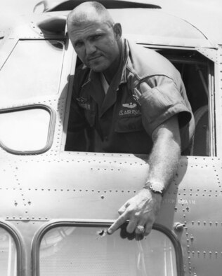 Maj. Ralph Dresser pointing to a bullet hole in a window dangerously near the pilot’s seat on a C-123B. (U.S. Air Force photo)