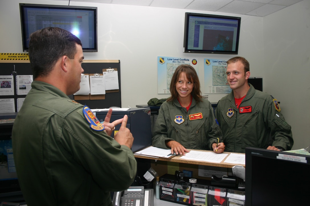Capt. Aaron Tillman, 89th Flying Training Squadron, and his fiancee, Christina Mittleider, recieve a briefing from Maj. Travis Price, 97th FTS, before taking part in "Taxi Day" Sept. 27.  (U.S. Air Force photo/Staff Sgt. Tonnette Thompson)