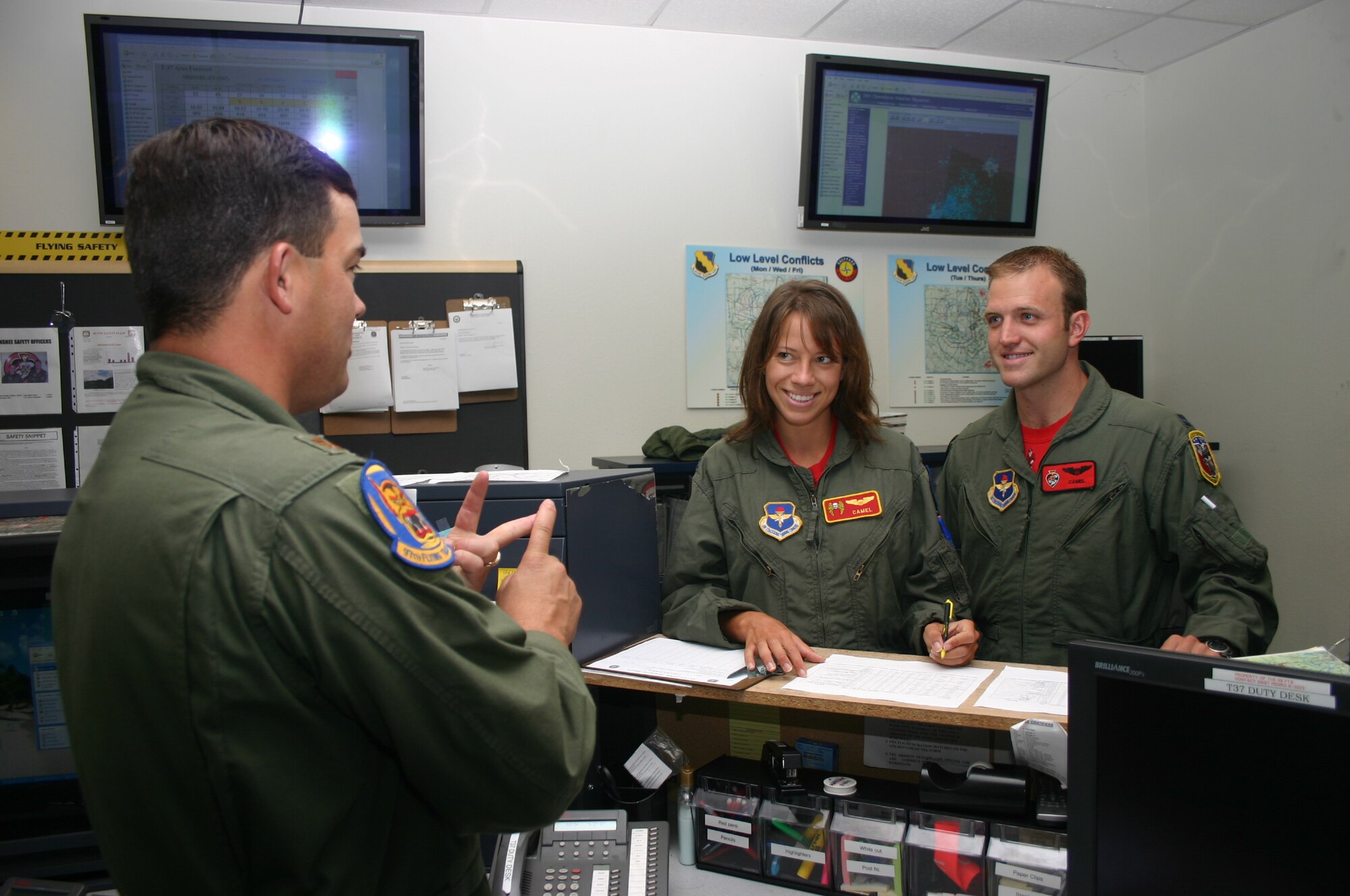 Capt. Aaron Tillman, 89th Flying Training Squadron, and his fiancee, Christina Mittleider, recieve a briefing from Maj. Travis Price, 97th FTS, before taking part in "Taxi Day" Sept. 27.  (U.S. Air Force photo/Staff Sgt. Tonnette Thompson)