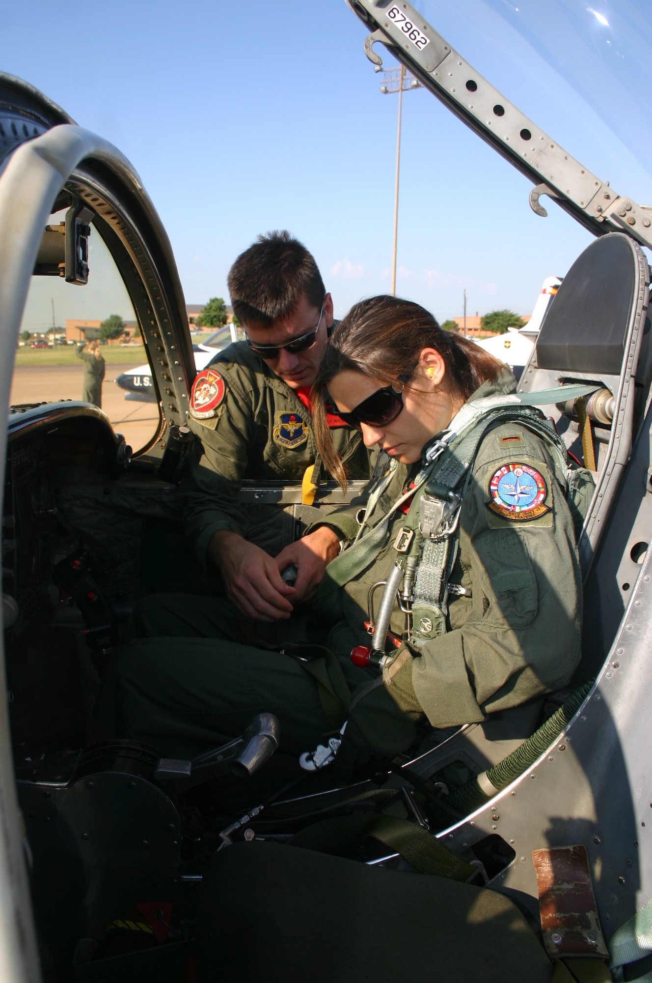 2nd Lt. Clay Westberry, 89th Flying Training Squadron, helps his wife, Candice, strap in for a joyride down the runway Sept. 27.  "Taxi Day" is an annual event for the 80th Flying Training Wing. (U.S. Air Force photo/Staff Sgt. Tonnette Thompson)