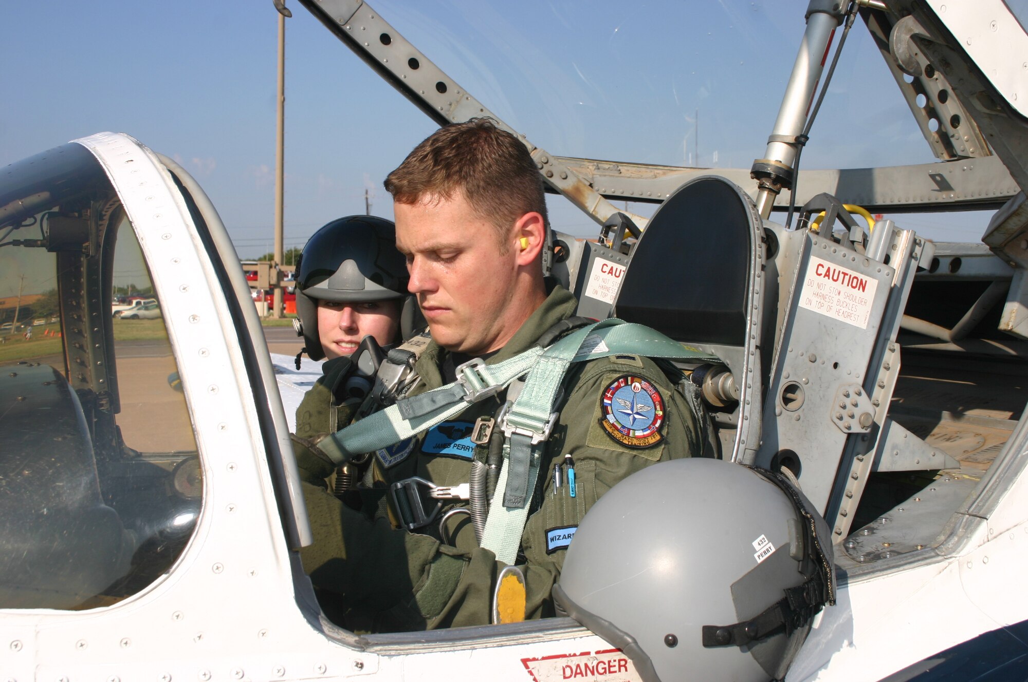 1st Lt. James Perry, 80th Operations Support Squadron, straps in while his wife, Chirstie, looks on as they prepare to take off Sept. 27.  "Taxi Day" is a tradition in the 80th Flying Training Wing. (U.S. Air Force photo/Staff Sgt. Tonnette Thompson)
