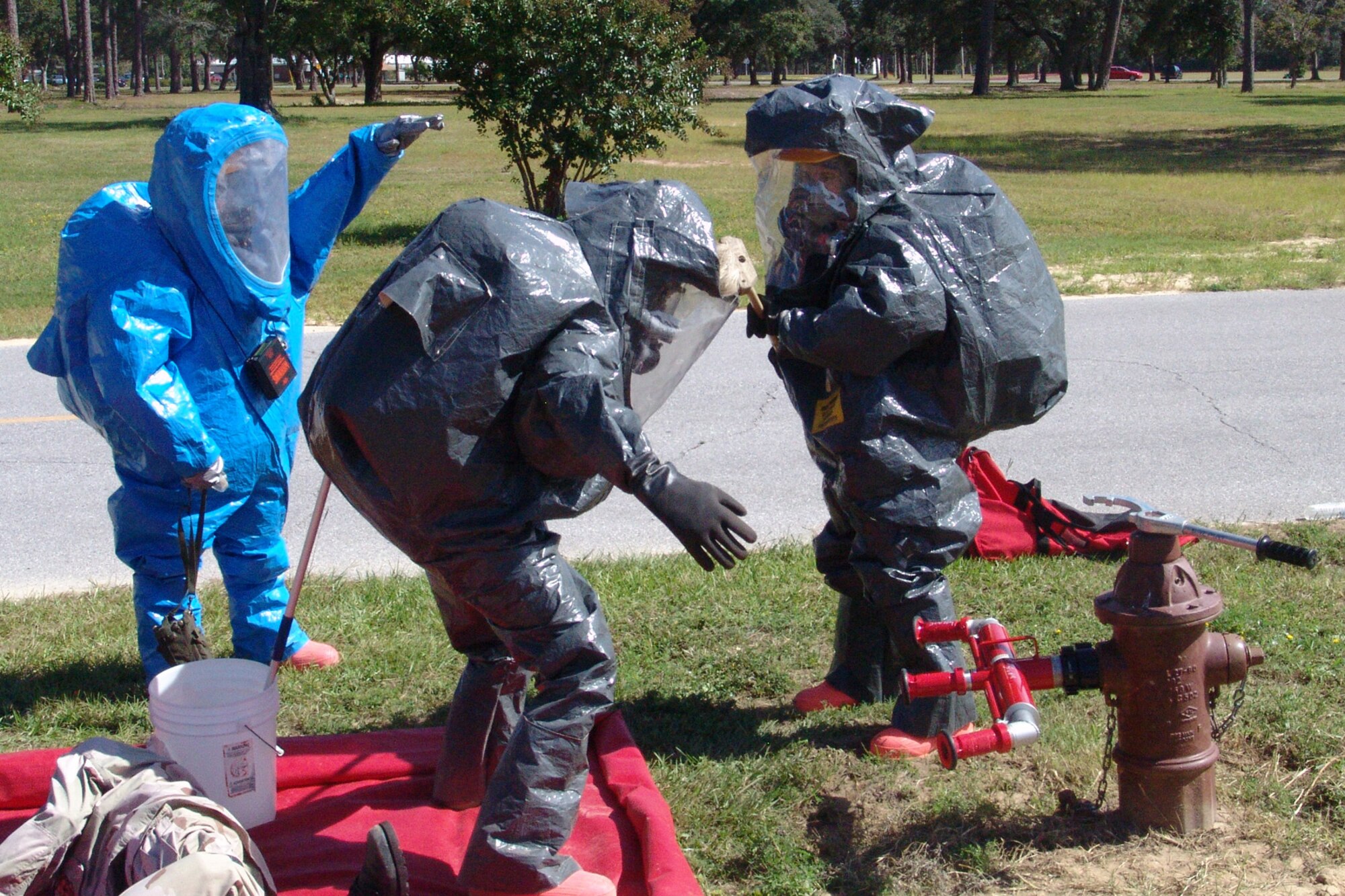 Senior Airman Jennifer Lefton decontaminates fellow firefighter Staff Sgt. Jeremy Phillips during a hazardous material training exercise.  The Airmen were participants in a hazardous material training session taught by instructors with the Department of Defense's Fire Academy at Goodfellow AFB, Texas. (photo by Lois Walsh)