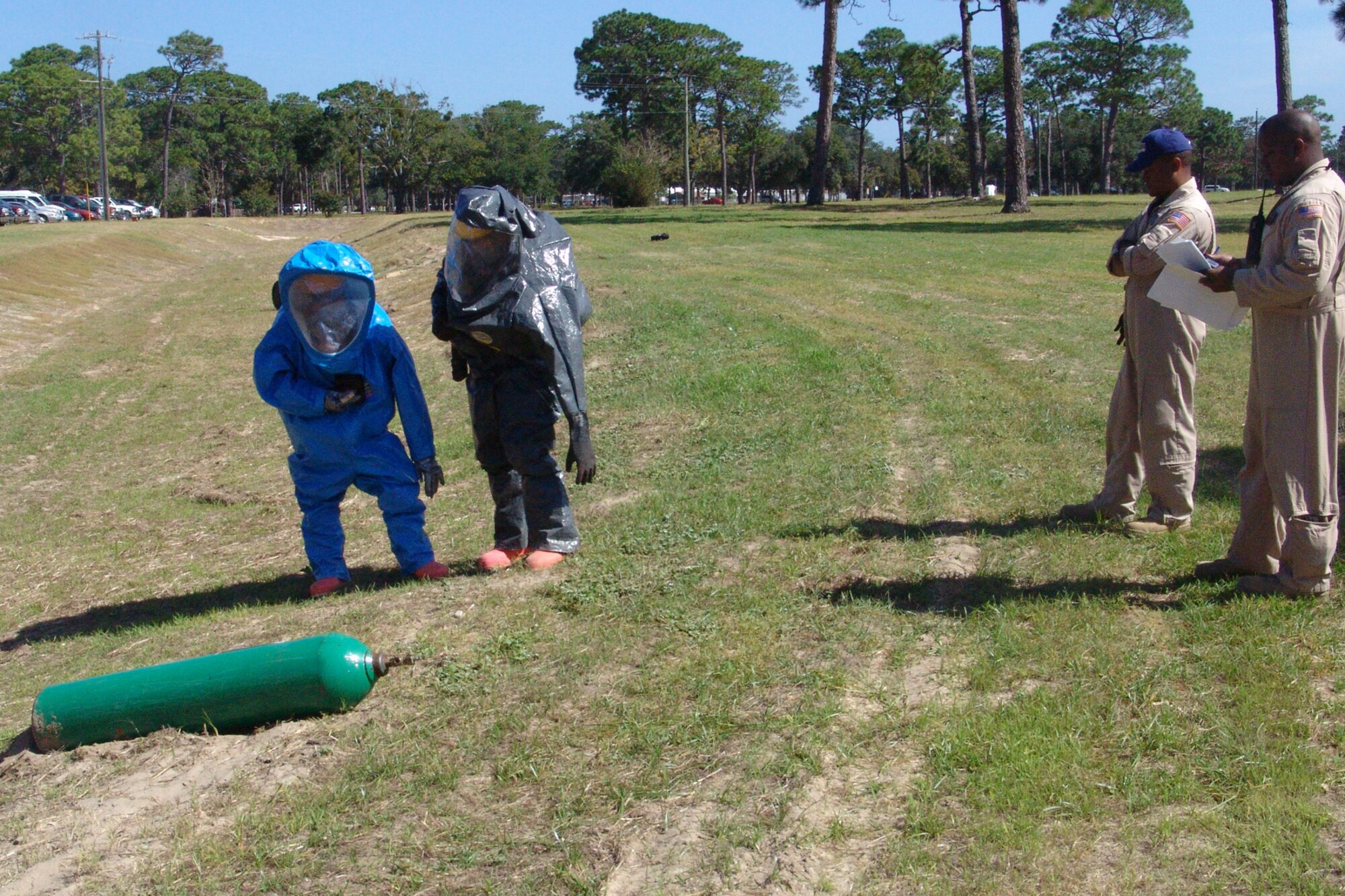 Firefighters Staff Sgt. Jeremy Phillips and Senior Airman Roy Campos, 96th Civil Engineer Squadron, are the reconnaissance team evaluating the potential of hazardous material emitting from a cylinder why DOD Fire Academy instructors Tech Sgt. Henry Stephens and Daryl Hogan observe. (USAF photo by Lois Walsh)                           
