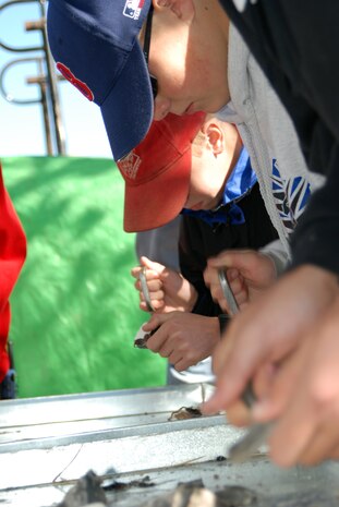 Several Boy Scouts attempt to start a fire using flint rock, steel and pieces of rope during the Boy Scout Expo on Saturday. (Photo by Airman 1st Class Robert Biermann)