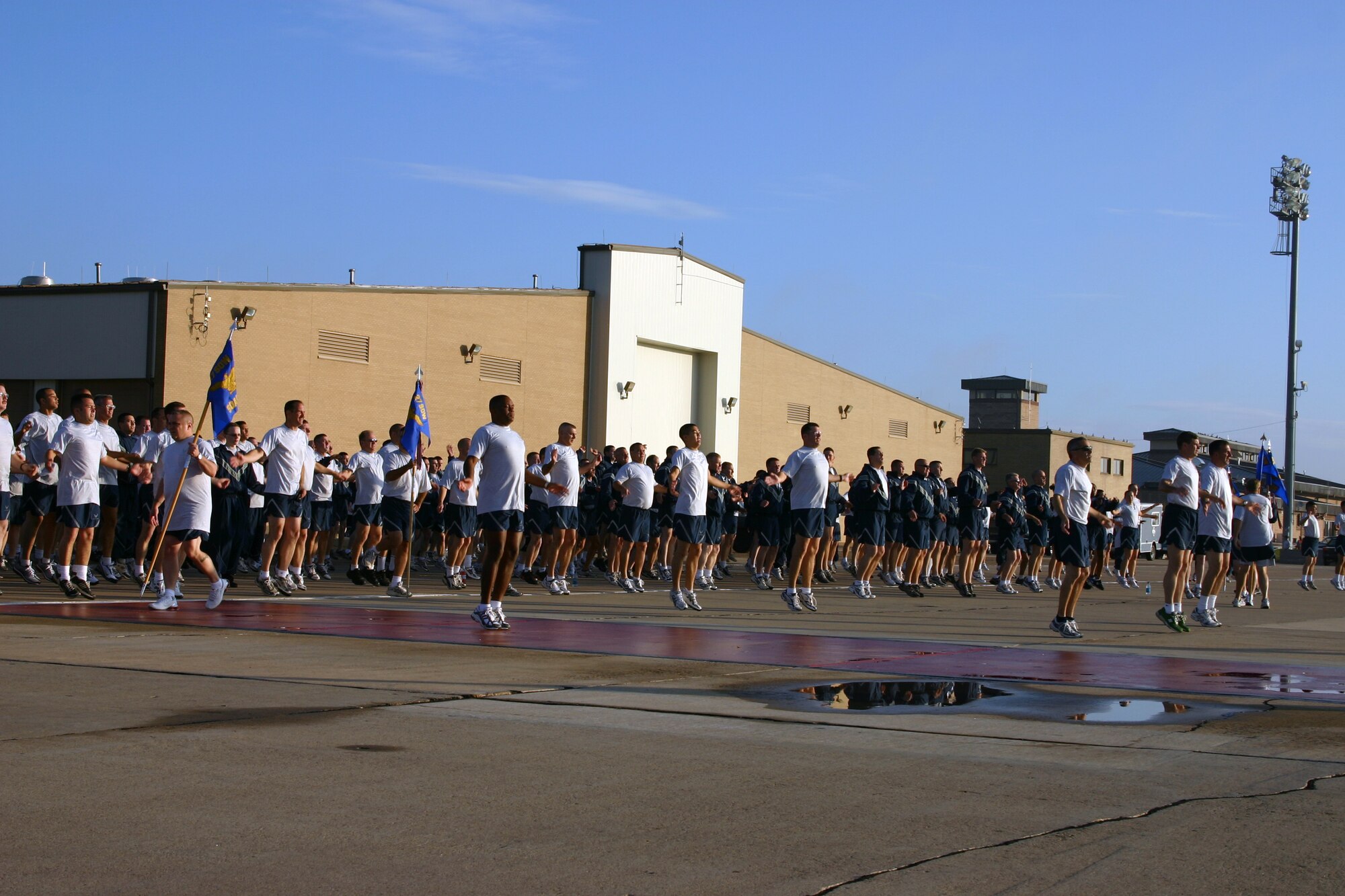 CANNON AIR FORCE BASE, N.M. -- Airmen do jumping jacks before beginning a two-mile commando run on the base flightline Tuesday morning. Airmen from the 27th Special Operations Group and 27th Special Operations Maintenance Group participated in the run. (U.S. Air Force photo by Airman Elliott Sprehe)