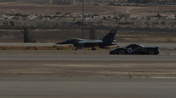 An F-16 Fighting Falcon, one of the Air Force’s most powerful single-engine fighters, races an XJR15 Jaguar down a one-mile stretch of Nellis  Air Force Base's parallel runways, Sept. 29, 2007. Autocross is a two day event that includes an fighter vs car race, a Mile Shoot Out, and a vehicle display.  (Air Force Photo by Airman 1st Class Nadine Y. Barclay)