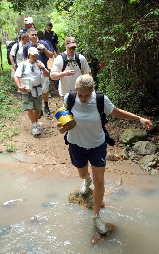 Staff Sgt. Melinda Atencio leads a group of military members across a stream during a hike to deliver food Sept. 29 to a village in the mountains near Comayagua, Honduras. The hike was sponsored by the Joint Task Force-Bravo Chapel from Soto Cano Air Base, and consisted of 55 volunteers who delivered approximately 450 pounds of supplies. (U.S. Air Force photo/Staff Sgt. Austin May)