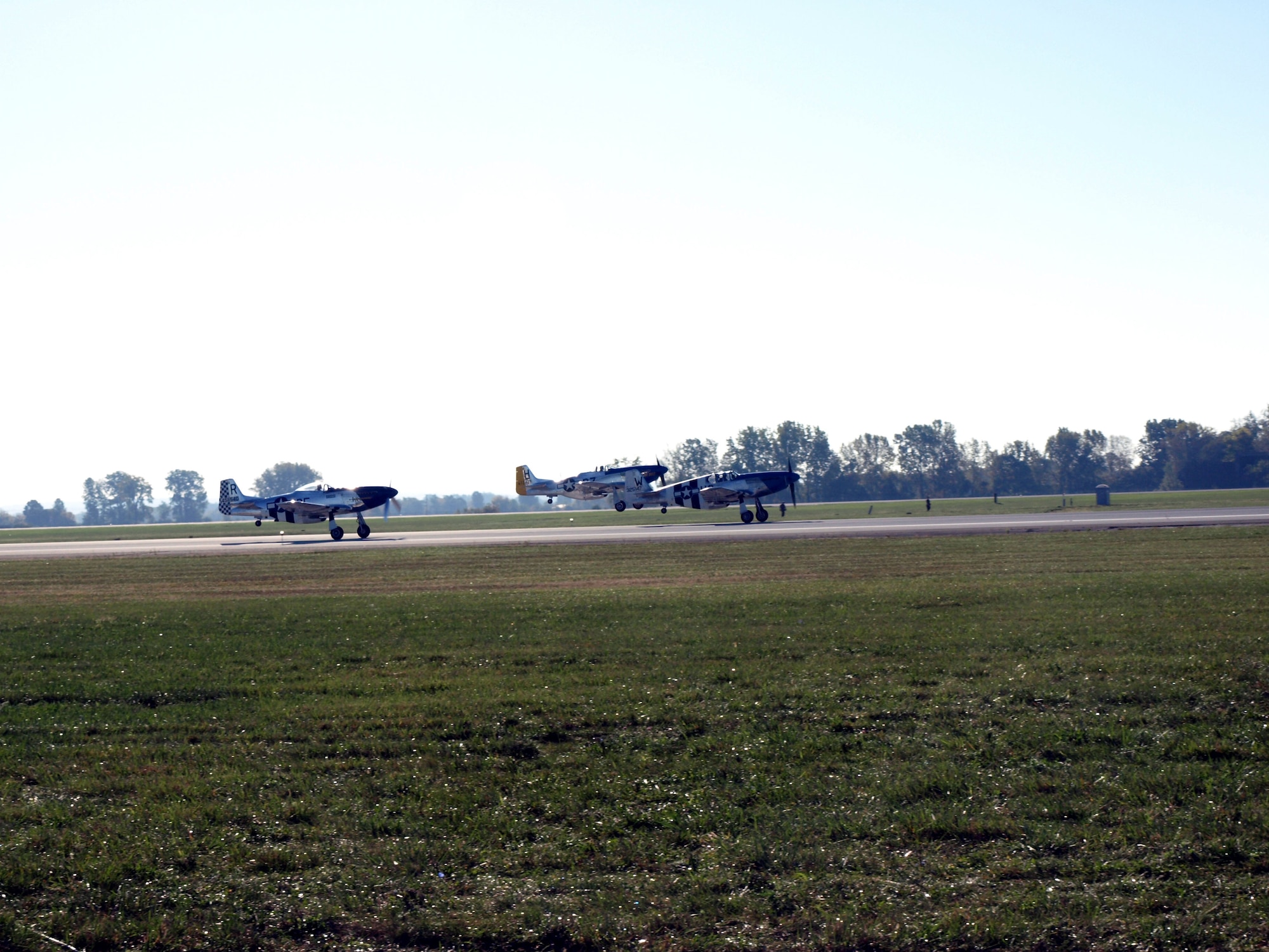 Three Mustangs take to the air during the 2007 second, and final, Gathering of Mustangs and Legends at Rickenbacker International Airport outside Columbus, Ohio. The first GML was held in April 1999 with 65 Mustangs. In 2007, the ramp at Rickenbacker held more than 150 Mustangs and other warbirds. (Air Force photo by Ron Scharven)