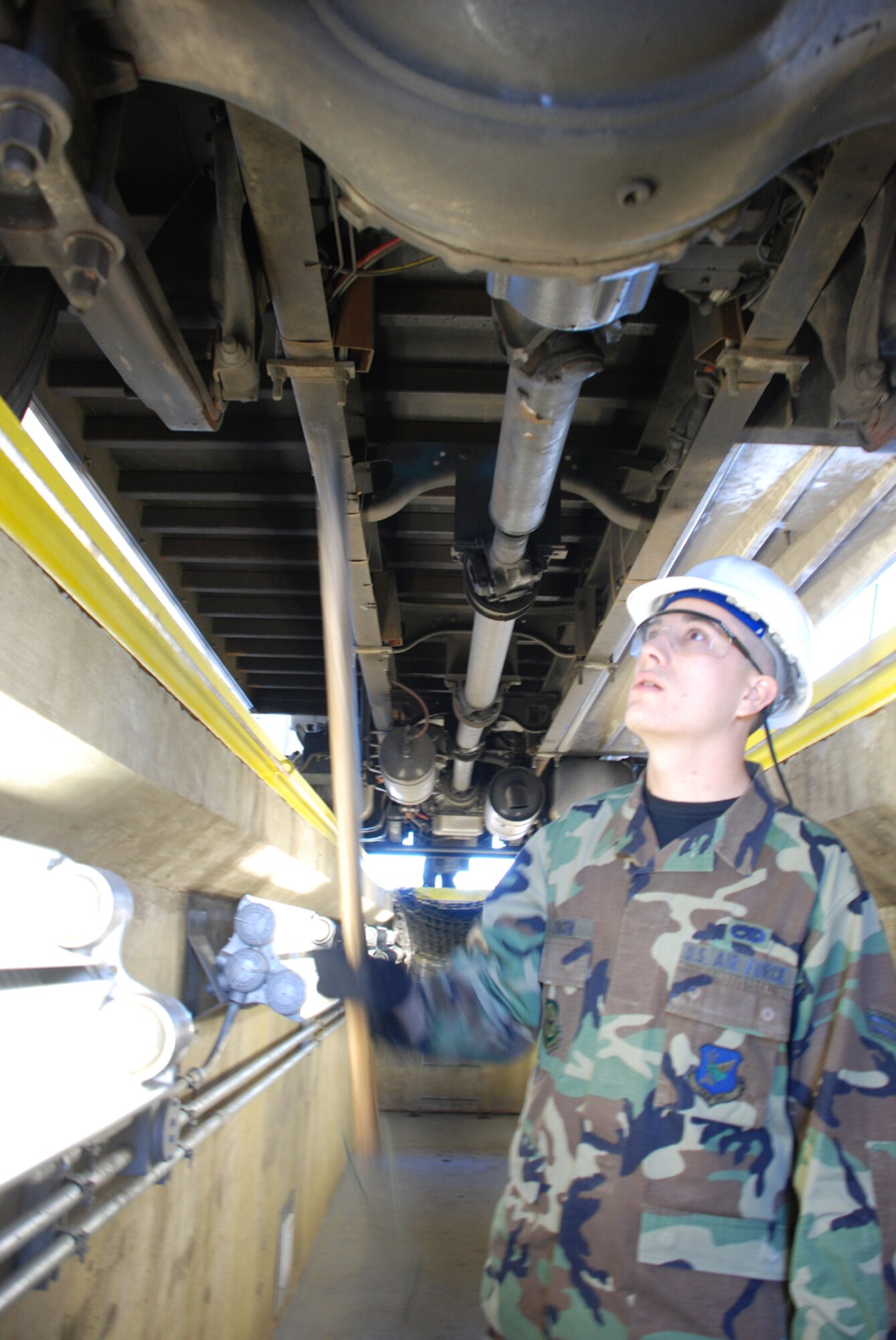Airman 1st Class Craig Spencer, 305th Maintenance Squadron member augmenting the 305th Security Forces Squadron at Checkpoint 9, inspects the underside of a commercial vehicle prior to being granted entrance to the base Sept. 17. (U.S. Air Force photo/Staff Sgt. Kelly White)

