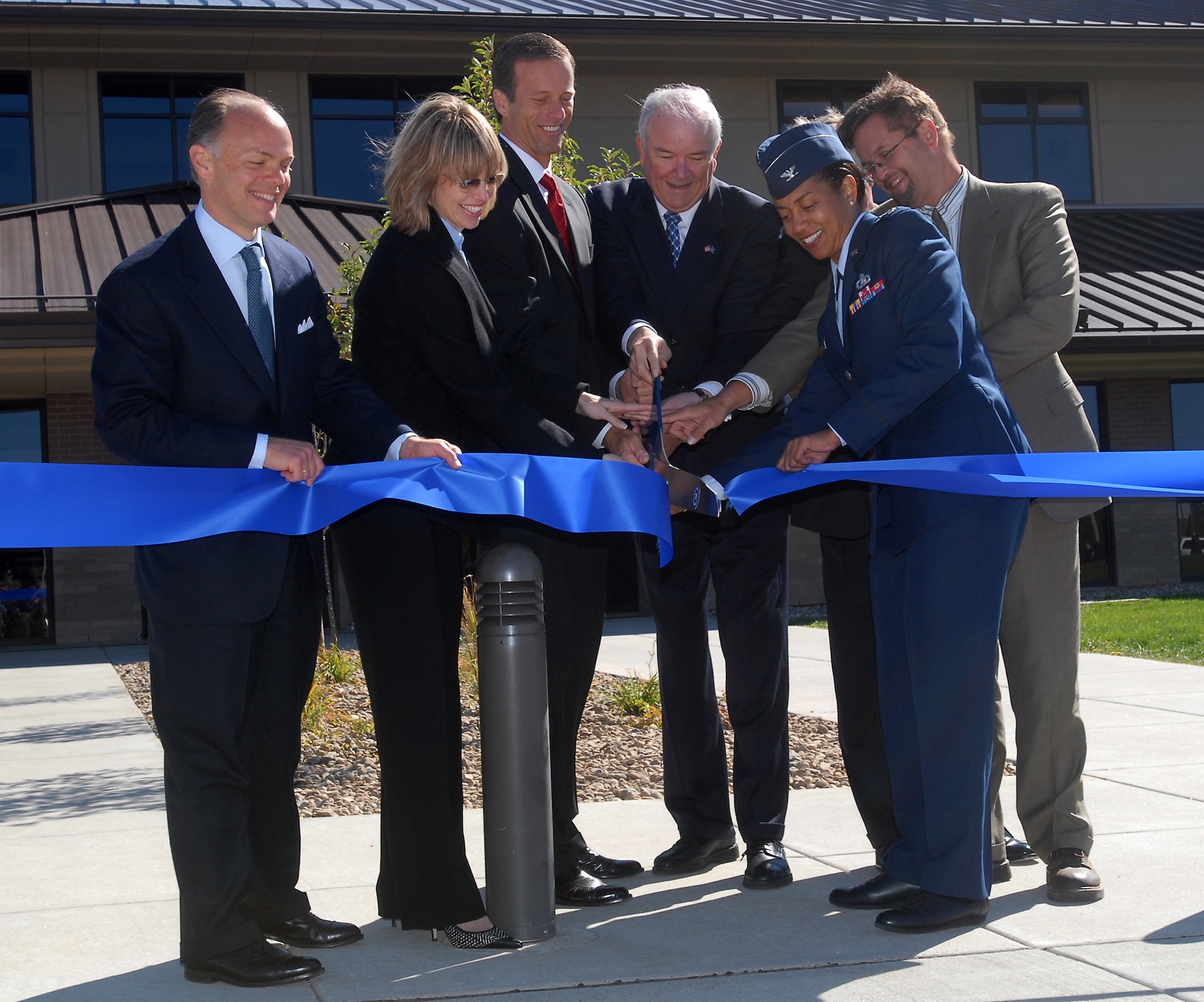The Air Force Financial Services Center grand opening and assumption of command ceremony ended with a ribbon cutting. From left, Assistant Air Force Secretary John G. Vonglis, Rep. Stephanie Herseth-Sandlin (D-SD), Sen. John Thune (R-SD), Air Force Secretary Michael Wynne, Col. Judy Perry, AAFSC commander, and Darryl Shoemaker of Sen. Tim Johnson's office. (Photo by Steve McEnroe,Rapid City Journal staff; photo courtesy of RJC)
