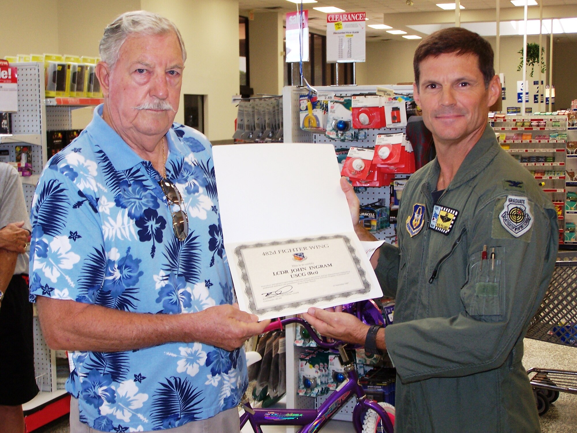 Col. Rob Polumbo, 482nd Fighter Wing Vice Commander presents retired U.S. Coast Guard Lt. Cmdr. John Ingram the 2007 Retiree Activities Office Volunteer of the Year Award during a ceremony at the Homestead Air Reserve Base Exchange, Sept. 28, 2007.  In 1979, Ingram retired from the U.S. Coast Guard with over 30 years of service.  He continued his service to the military as a volunteer with the American Red Cross working at the Homestead Air Force Base hospital.  Today, Lt. Cmdr. Ingram is approaching his 28th year of volunteering with the RAO at Homestead ARB, Fla. (U.S. Air Force photo/Tim Norton)