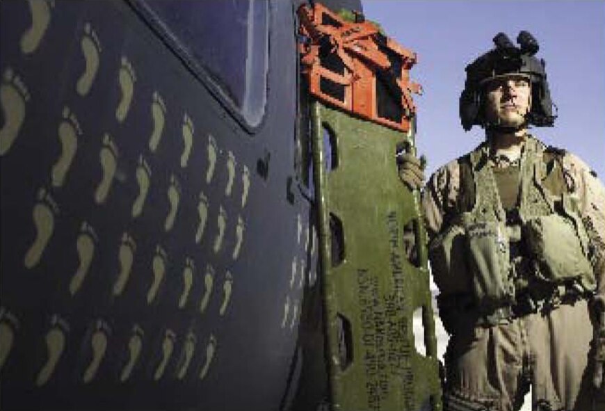 KANDAHAR AIRFIELD, Afghanistan -- Tech. Sgt. Mark De Corte, 5th Medical Support Squadron, Non commissioned officer in charge of medical readiness, poses next to an HH-60 Pave Hawk, while deployed to Afghanistan as a member of the 33rd Expeditionary Rescue Squadron based in Kandahar. The tan footprints painted on the helicopter represent lives saved. Sergeant DeCorte was recently selected to take part in the "Why We Serve" program. He will be traveling around the country telling his story. (U.S. Air Force photo by Senior Airman Brian Ferguson)