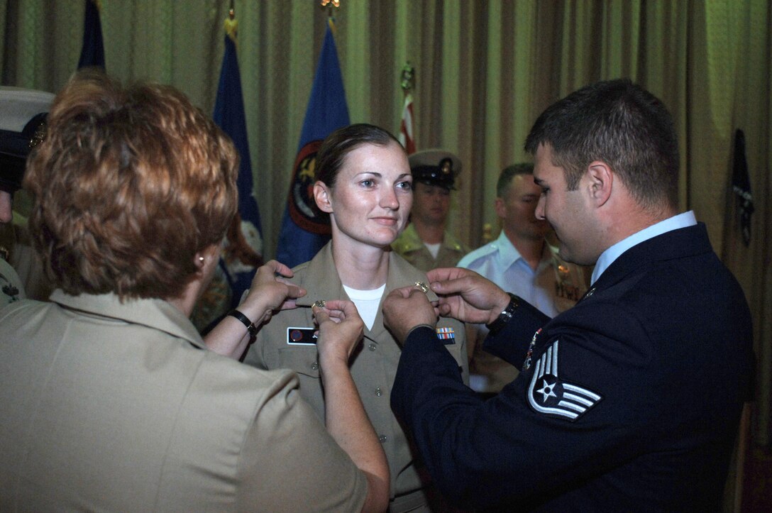 Newly inducted Chief Petty Officer Michell Jordan, has anchors that belonged to her father, pinned on her lapel by her husband Tech. Sgt. (Sel) Marshall Jordan (right) and her sponsor Chief Petty Officer Debbie Miller at the annual Navy Chief Petty Officer Induction Ceremony, at RAF Alconbury, UK, September 21, 2007.   Chief Pety Officer  Jordan is stationed at the Joint Analysis Center, RAF Molesworth and hails from Waukegan, Ill. (U.S. Air Force Photo by Staff Sgt. Jocelyn Rich).