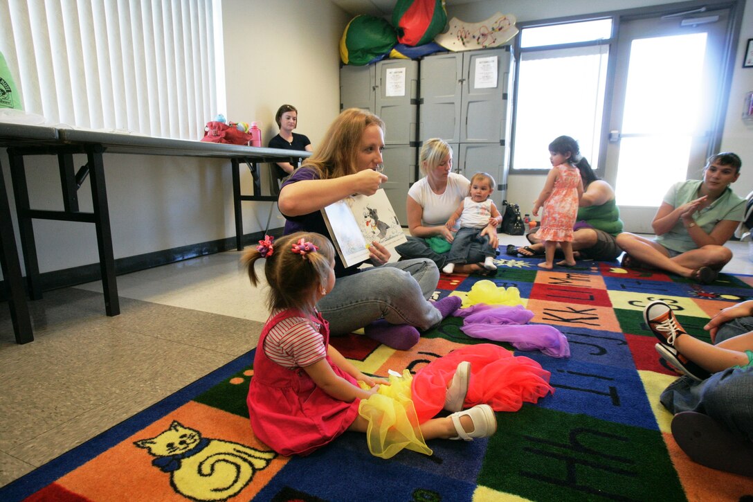 Mackenzie Schmitt, 2, listens intently as Heather Harris, Kindermusik educator, reads a story book to the children during a Kindermusik class Wednesday.