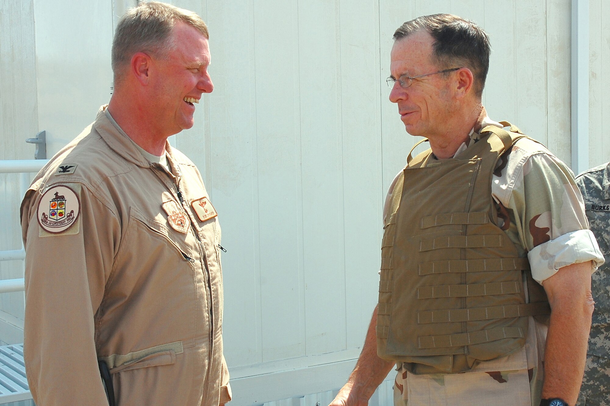 Adm. Michael Mullen, the new chairman of the Joint Chiefs of Staff, chats with Col. Robert Swisher, the commander of the 386th Air Expeditionary Wing, during a visit Oct. 3 to a deployed location in Southwest Asia.  (U.S. Air Force photo/Staff Sgt. Tia Schroeder)