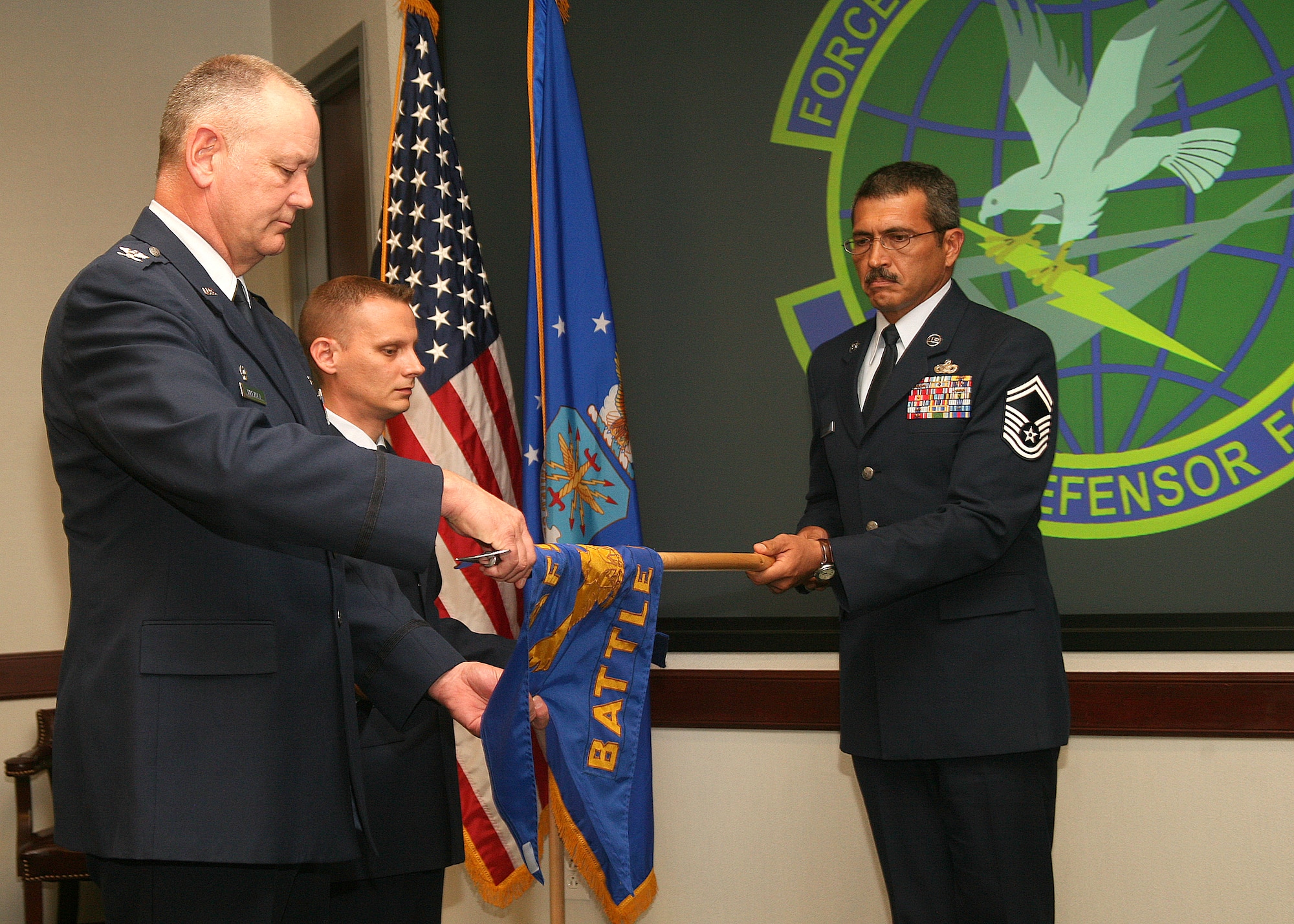 Col. Bob Tirevold cases the Force Protection Battlelab guidon Sept. 28 during the inactivation ceremony at Lackland Air Force Base, Texas.  Assisting are Senior Master Sgt. Dan Lederman (right) and Master Sgt. Drew Stimely.  Prior to the inactivation, Colonel Tirevold was the battlelab commander, Sergeant Lederman was the superintendent of the Modeling and Simulation Division, and Sergeant Stimely was the NCOIC of operations for the Concepts Division.  (U.S. Air Force photo/Robbin Cresswell)