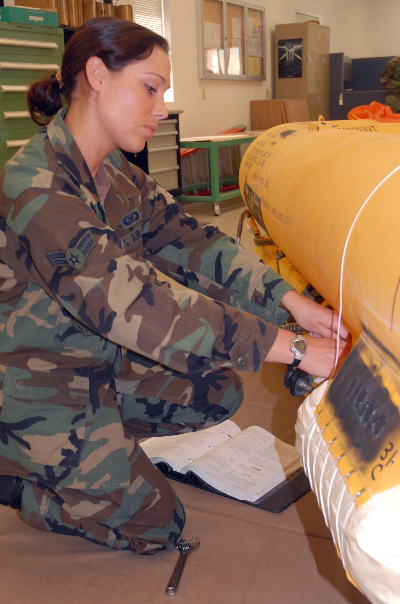 Airman 1st Class Sharon Clark, 437th Operations Support Squadron aircrew flight equipment specialist, practices installing a 46-man life raft bottle on a raft Monday at the flotation section on base. (U.S. Air Force photo/Airman Melissa White)