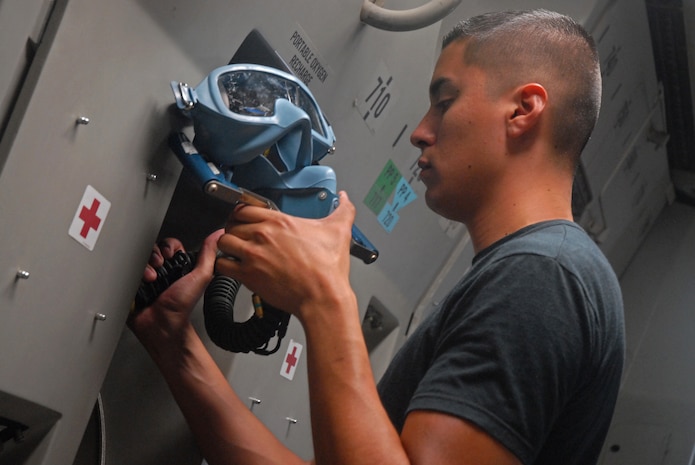 Airman 1st Class Francisco Quezada, 437th Operations Support Squadron aircrew flight equipment journeyman, places an emergency breathing device in a C-17 on Charleston AFB Tuesday. (U.S. Air Force photo/Airman Melissa White)