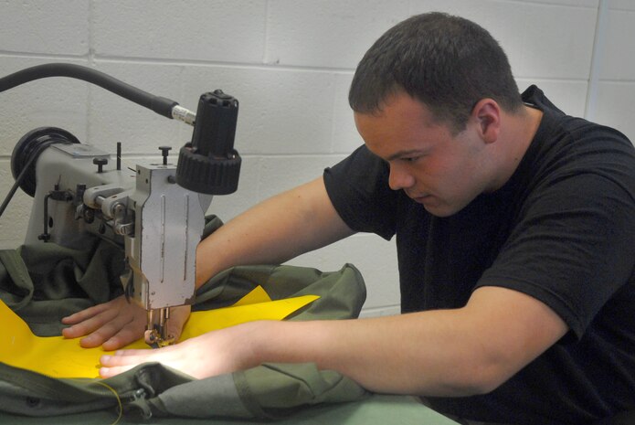 Senior Airman Virgil Smith, 437th Operations Support Squadron aircrew flight equipment journeyman, sews decals on an equipment bag Tuesday on Charleston AFB. (U.S. Air Force photo/Airman Melissa White)