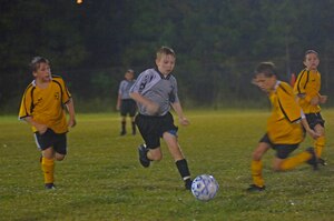 Jacob LeCroy, 9, son of Tech. Sgt. William LeCroy, works his way through the Hannahan Battery team in the rain Oct. 2 on Charleston AFB.  (U.S. Air Force Photo/Staff Sgt. April Quintanilla)