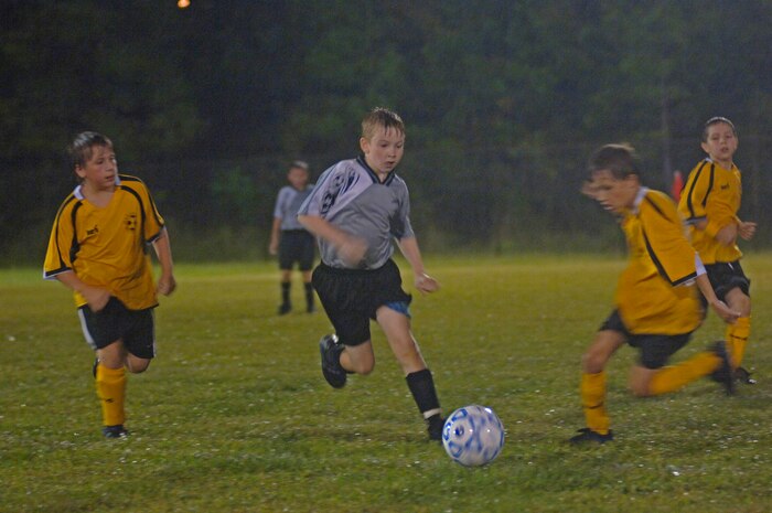 Jacob LeCroy, 9, son of Tech. Sgt. William LeCroy, works his way through the Hannahan Battery team in the rain Oct. 2 on Charleston AFB.  (U.S. Air Force Photo/Staff Sgt. April Quintanilla)