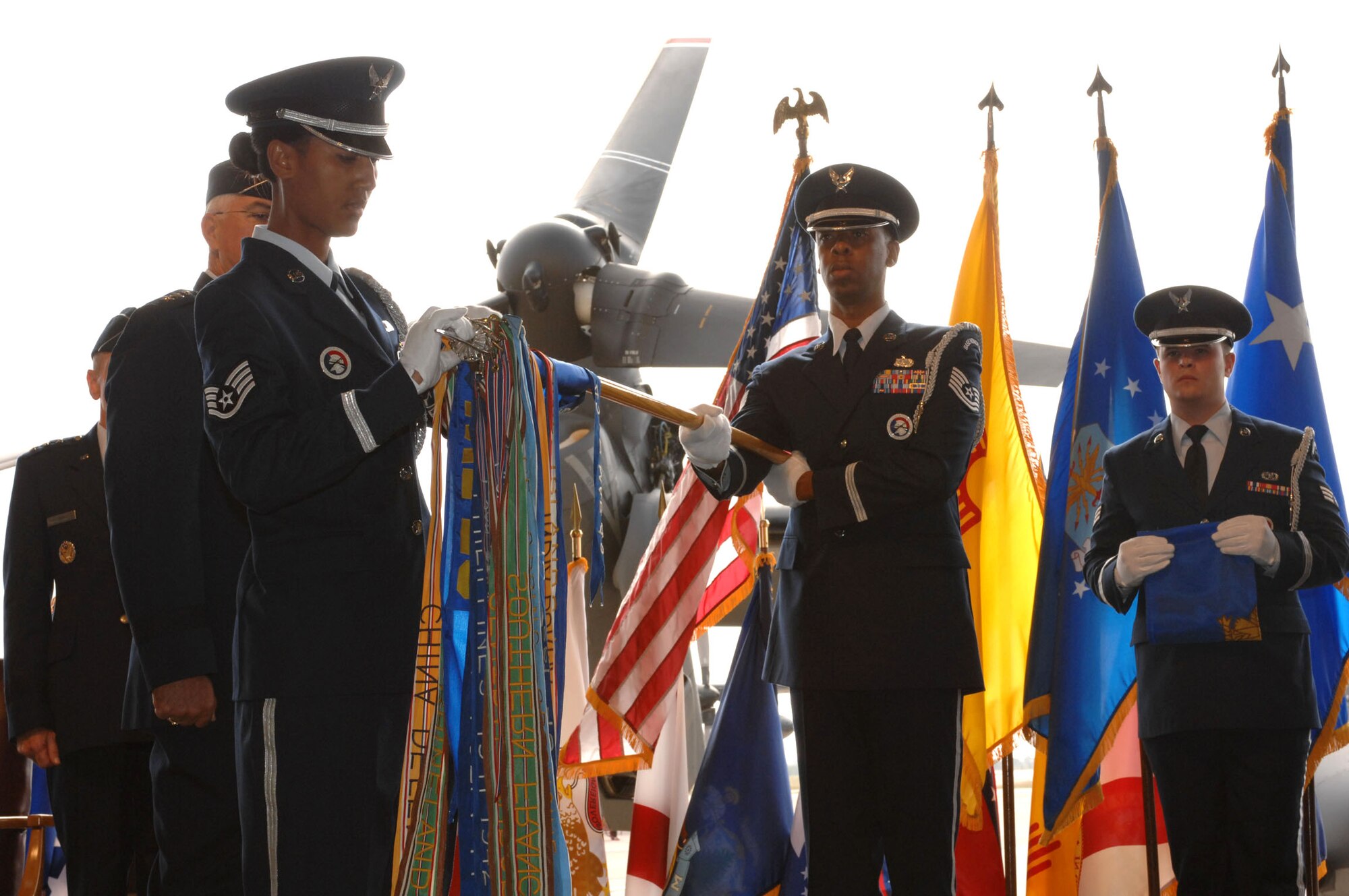 Honor Guard members Staff Sgt. Torrie McCutcheon (left) and Tech. Sgt. Rodney Barner remove the 27th Fighter Wing flag from the base guidon during the redesignation and change-of-command ceremony held Oct. 1 at Cannon Air Force Base, N.M. The flag was replaced by the new 27th Special Operations Wing flag. The unit is now one of two Air Force active-duty special operations wings in the United States. (U.S. Air Force photo/Airman 1st Class Evelyn Chavez) 