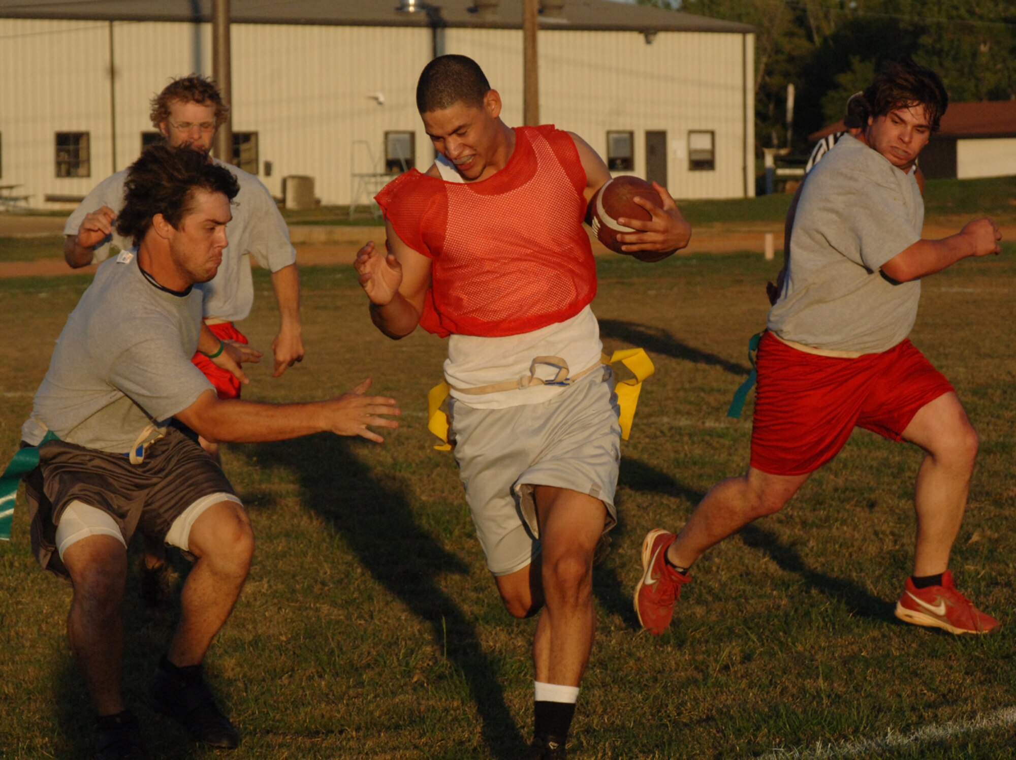 Senior Airman William Greenan, 14th Civil Engineer Squadron, runs the football up the sideline Tuesday night, while members of the DynCorp team try to grab his flag. The DynCorp intramural flag football team was victorious over the 14th CES team by a score of 28 to 12. (U.S. Air Force photo by Airman 1st Class Danielle Powell)
