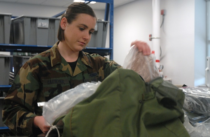 Airman 1st Class Megan Latteyer, 437th Logistics Readiness Squadron war readiness technician, inspects the contents of a C-bag prior to the mobility processing line Tuesday at the mobility processing center on base. (U.S. Air Force photo/Airman Melissa White)