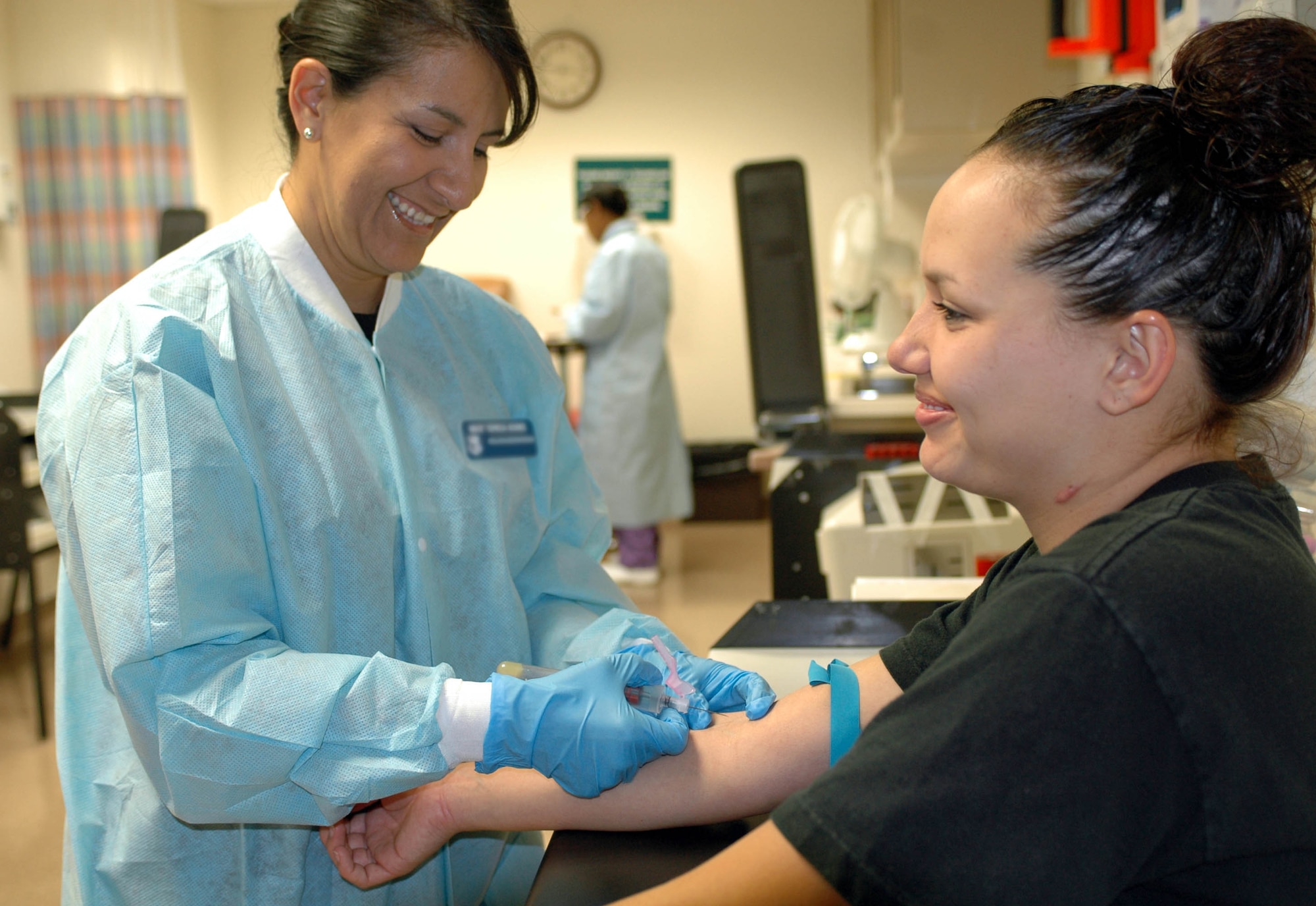 Master Sgt. Teresa Gomez, (left), 60th Diagnostics and Therapeutics Squadron NCOIC of Laboratory Services, prepares to draw blood from a patient. Sergeant Gomez was selected as Warrior of the Week. (U.S. Air Force photo/Staff Sgt. Candy Knight)