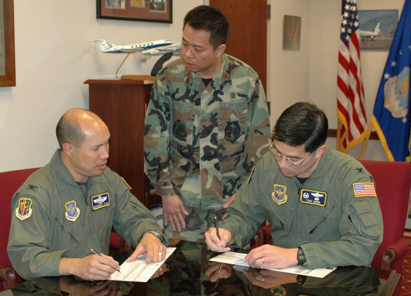 Col. GI Tuck, 60th Air Mobility Wing vice commander, and Col. Anthony Hinen, 615th Contingency Response Wing commander, sign the Combined Federal Campaign Proclamation Oct. 3 while Maj. Jim Yao, CFC representative looks on. The CFC collects contributions from federal employees, including servicemembers, on behalf of different charitable organizations. (U.S. Air Force photo/Airman 1st Class Kristen Rohrer)

