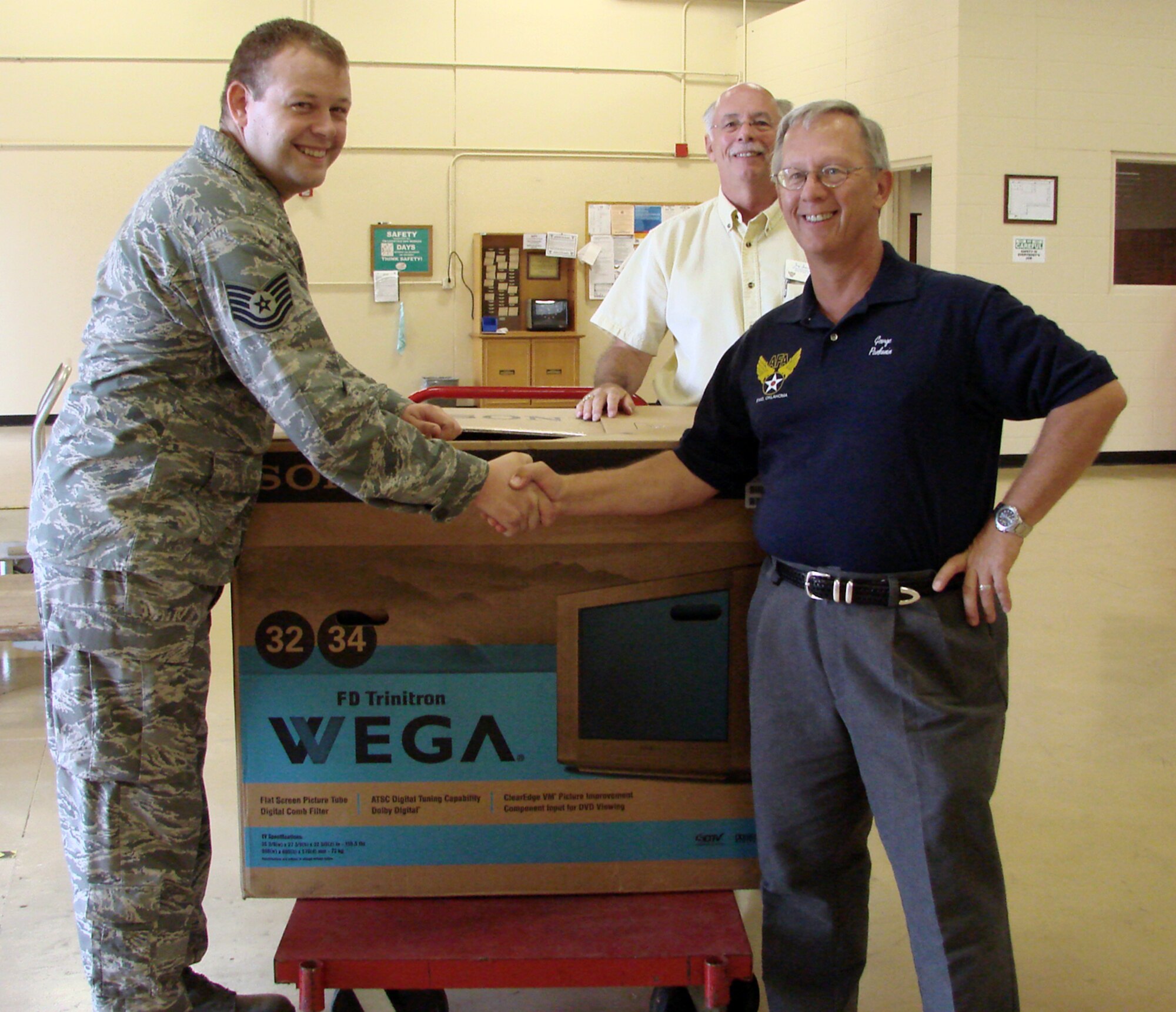 Tech. Sgt. Joseph Henson, 71st Communications Squadron, receives a 32-inch television Oct. 2 from Air Force Association representatives George Pankonin and Jay Jacobs. Sergeant Henson and other Team Vance members won prizes during Enlisted Appreciation Night in March while deployed. Sergeant Henson returned to Vance AFB Sept. 7 and was the last deployed person to pick up his prize.