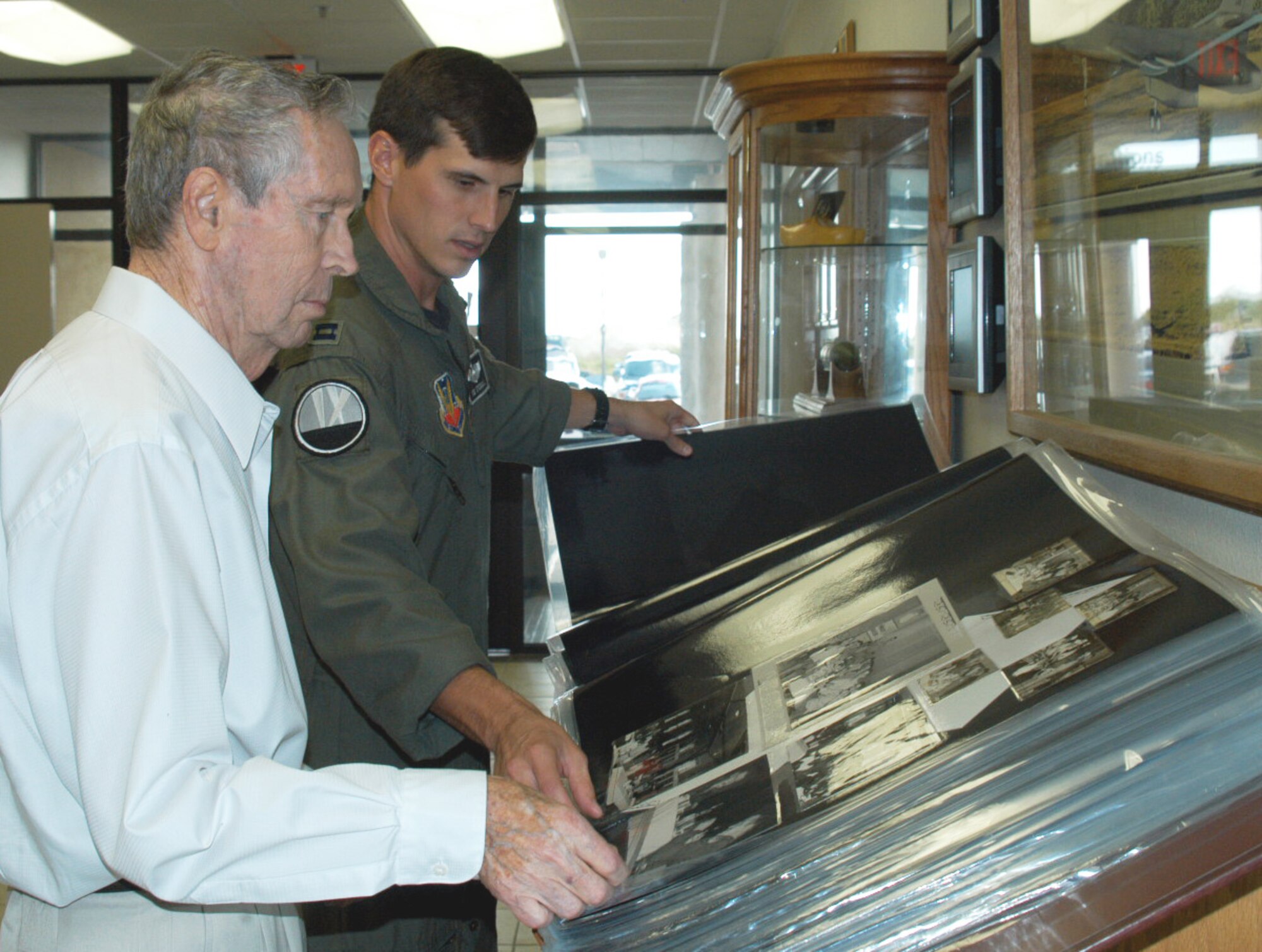 Retired Maj. Leland Madison, left, looks at Dyess history at the 9th Bomb Squadron with Capt. Sid Stegall, 9th BS pilot. Major Madison was a B-52 and B-57 pilot in the days of the Vietnam war and visited Dyess Oct. 1 to fly a B-1 simulator and tour the base's current operations. (U.S. Air Force photo by Senior Airman Carolyn Viss)                               