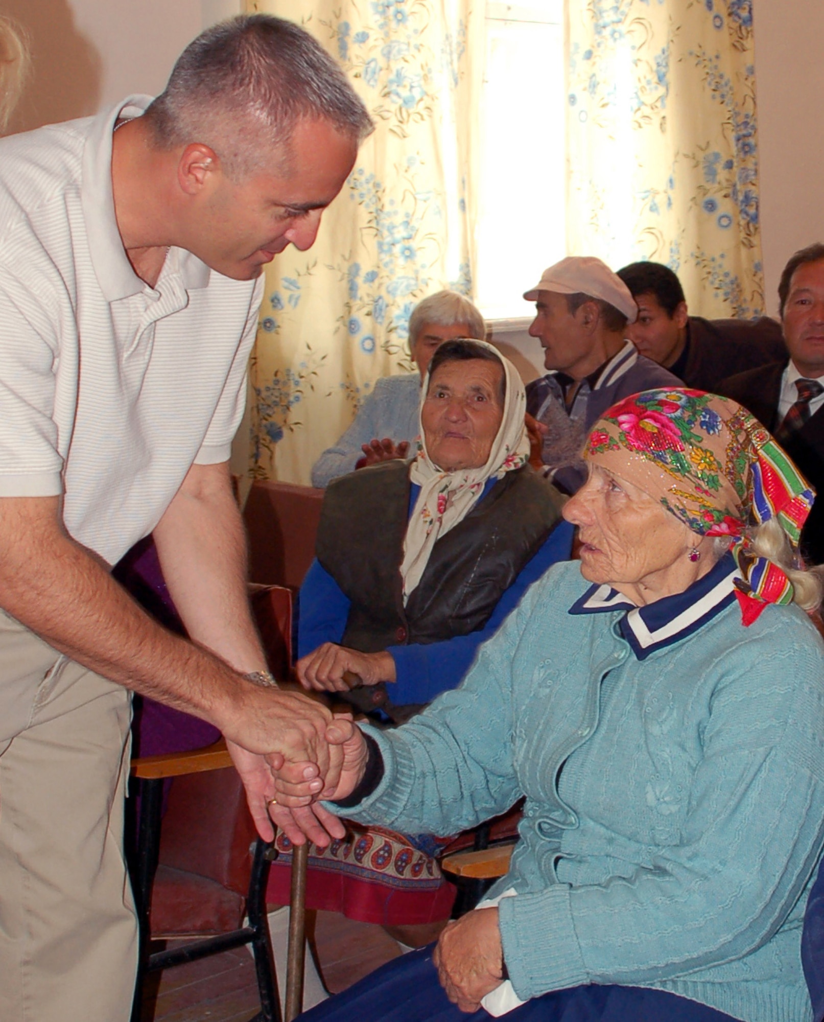 Col. Don Berchoff greets villagers Oct. 1 in the village of Oktyabra'skoe, Kyrgyzstan, during  the local Elders' Day celebration. Airmen from Manas Air Base handed out packages including blankets, rice, pasta, sugar, tea, cookies, crackers, thermos', insulated mugs, and more to elderly citizens during the celebration.The colonel is the 376th Expeditionary Mission Support Group commander. (U.S. Air Force photo/Senior Master Sgt. Stefan Alford)