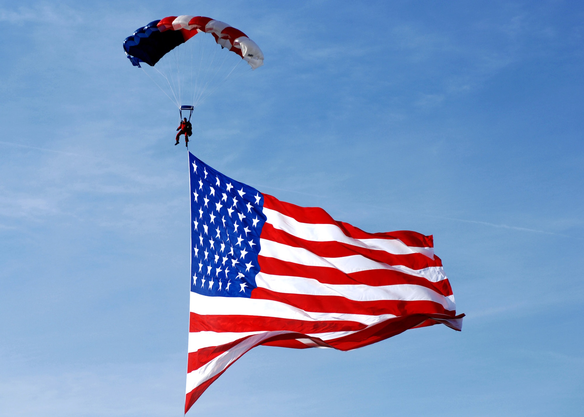 A parachuter drifts to the ground with the American flag during the opening ceremony for the Gathering of Mustands and Legends Sept. 28 at Rickenbacker International Airport in Ohio. (U.S. Air Force photo/Senior Airman Amanda Cain)
